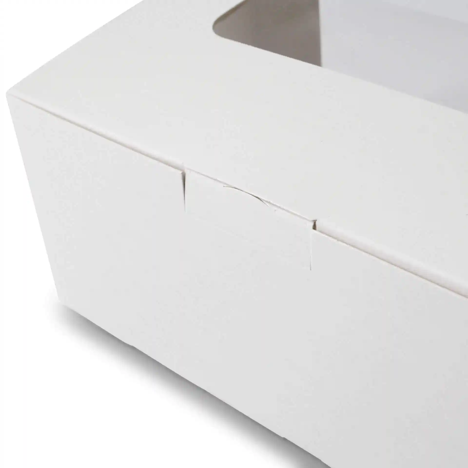 Close-up of a white cardboard cupcake box with a rectangular shape and a viewing window.