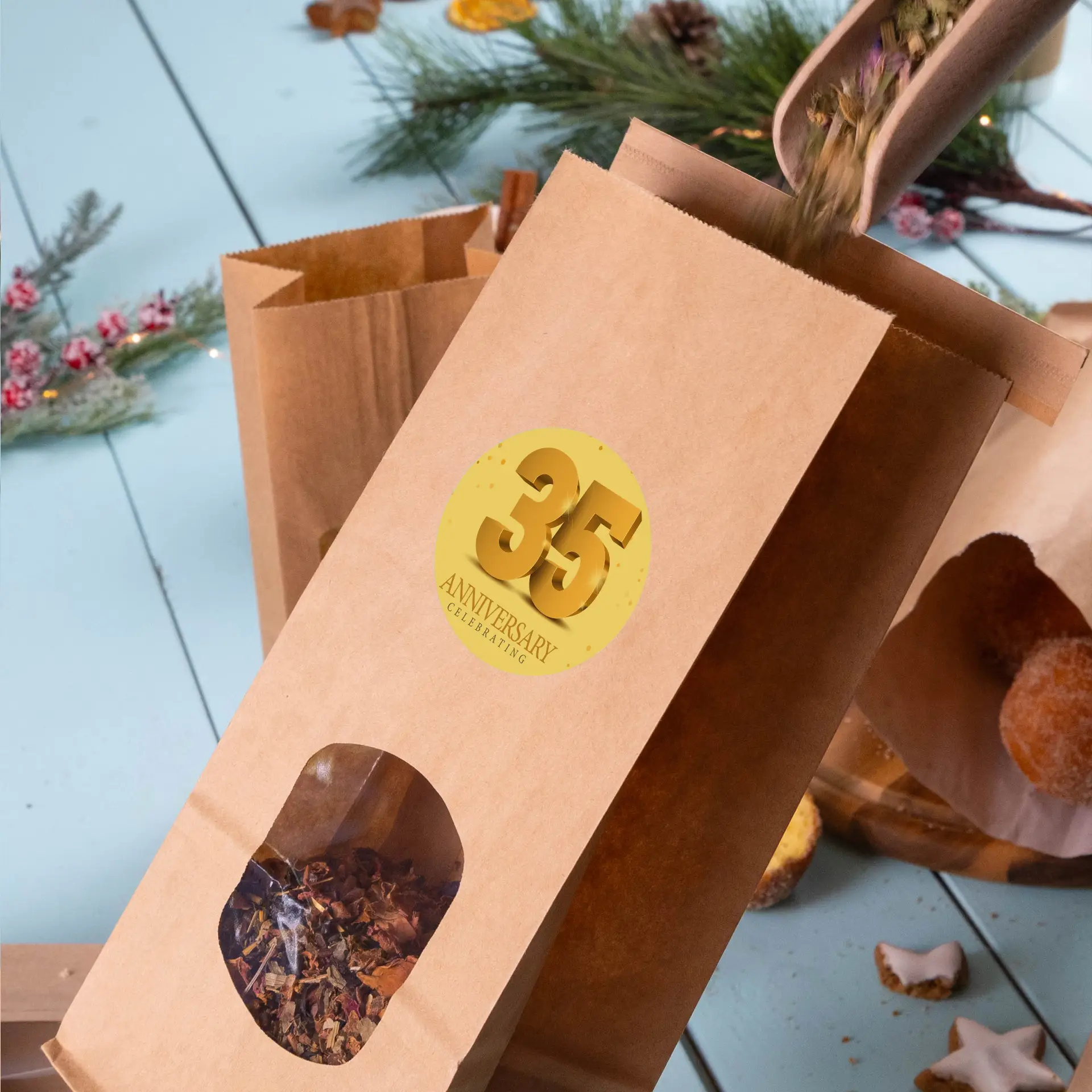 Brown kraft paper bag with a transparent window displaying dried herbs and a gold circular label stating "35 ANNIVERSARY CELEBRATING."