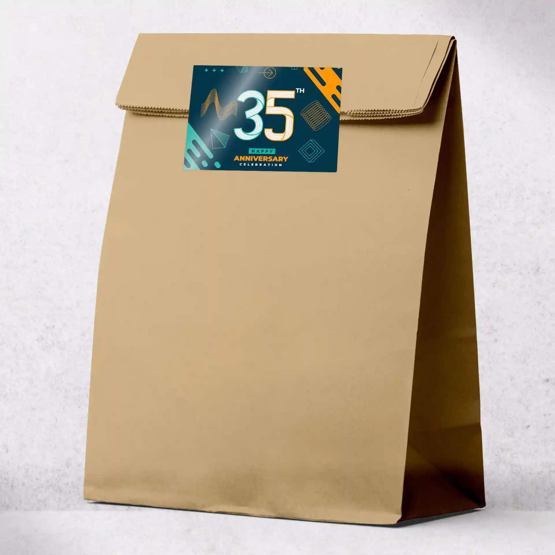 Brown paper bag with a printed rectangular label featuring a 35th anniversary design.