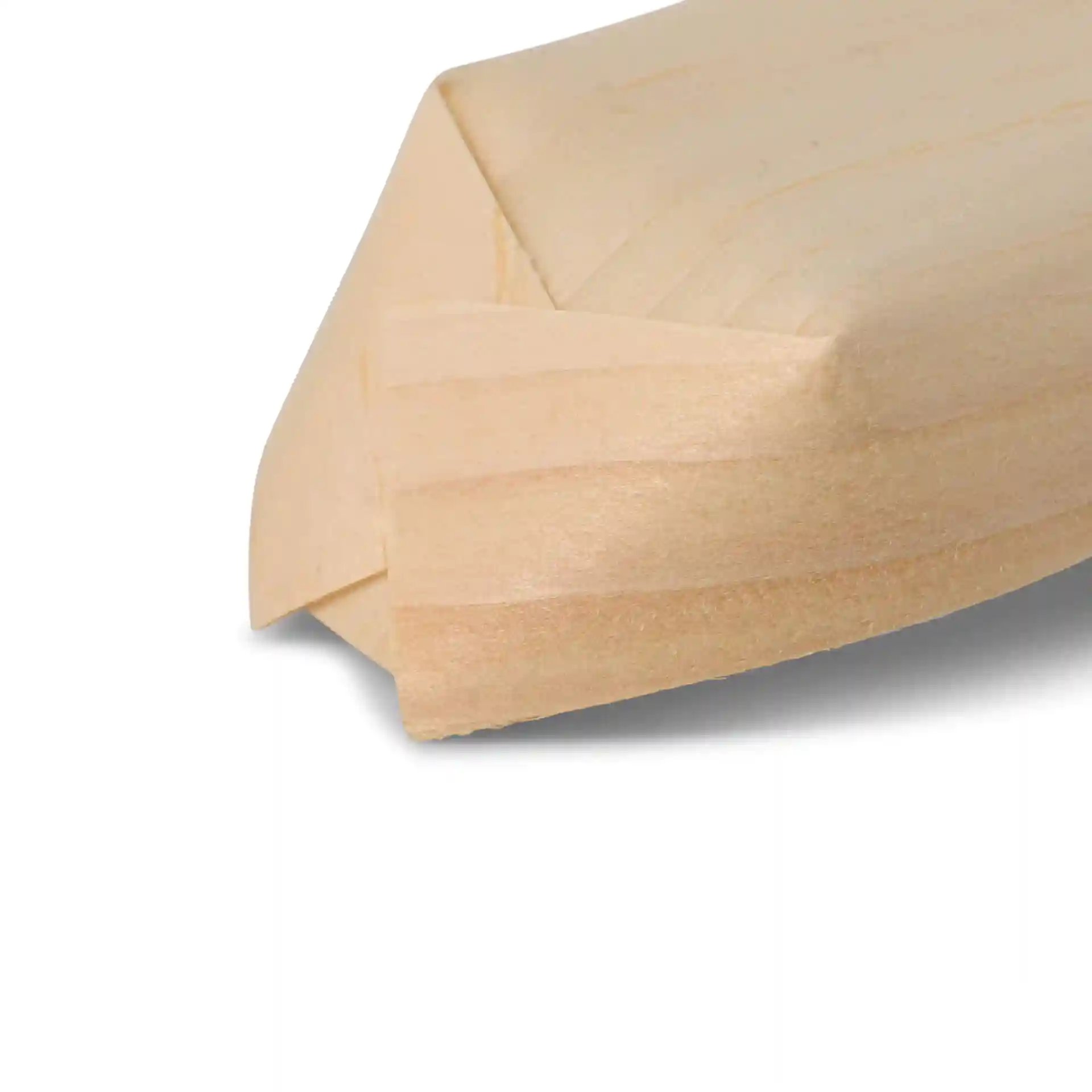 Close-up of a wooden boat-shaped item with a smooth, light brown surface and angled edges.