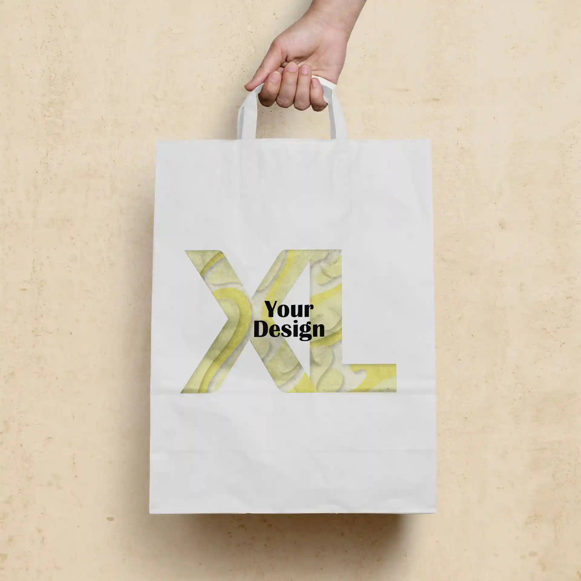 White paper carrier bag held by a hand, featuring a large "XL" design with the text "Your Design" on the front.