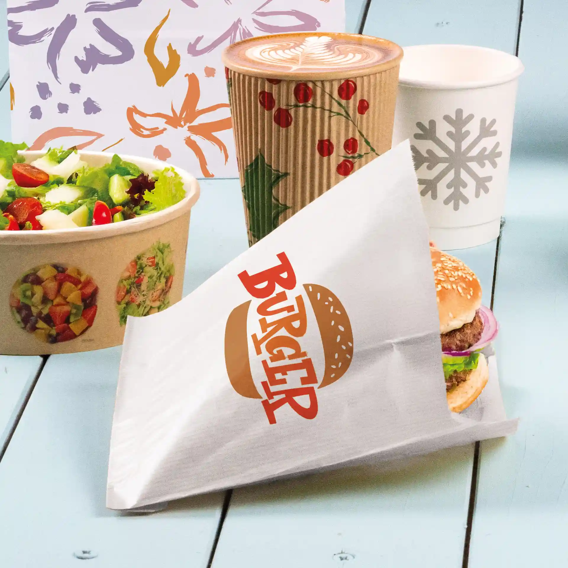 Weißer Burger-Sleeve mit dem Aufdruck "BURGER", hält einen Burger mit Sesambrötchen, Salat und Zwiebel, neben einem Salat und Getränken.