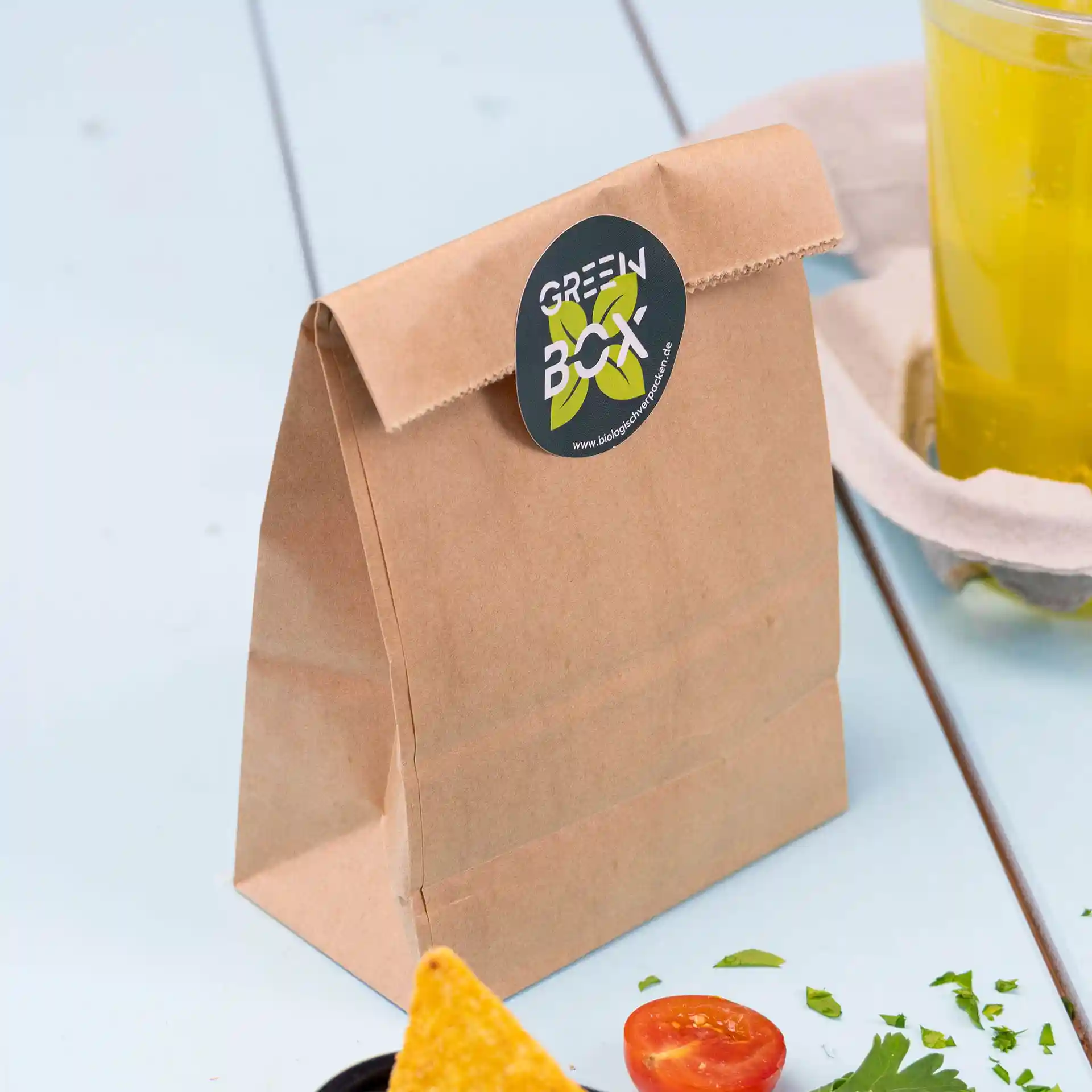 Braune Kraftpapier-Tüte mit Blockboden und einem runden Logo-Aufkleber oben.
