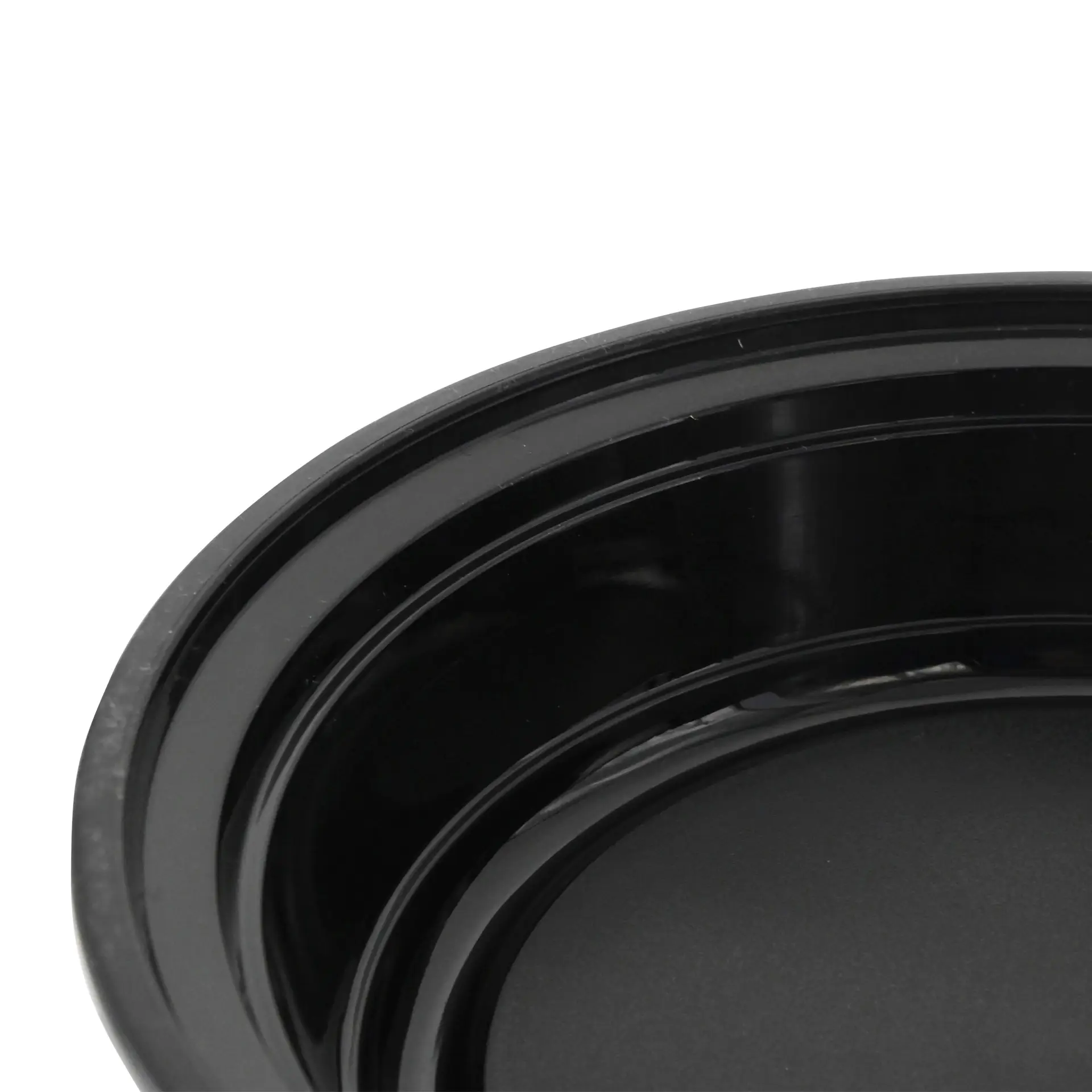Reusable round black plate made of PP; suitable for hot and cold dishes; shown from a close angle.