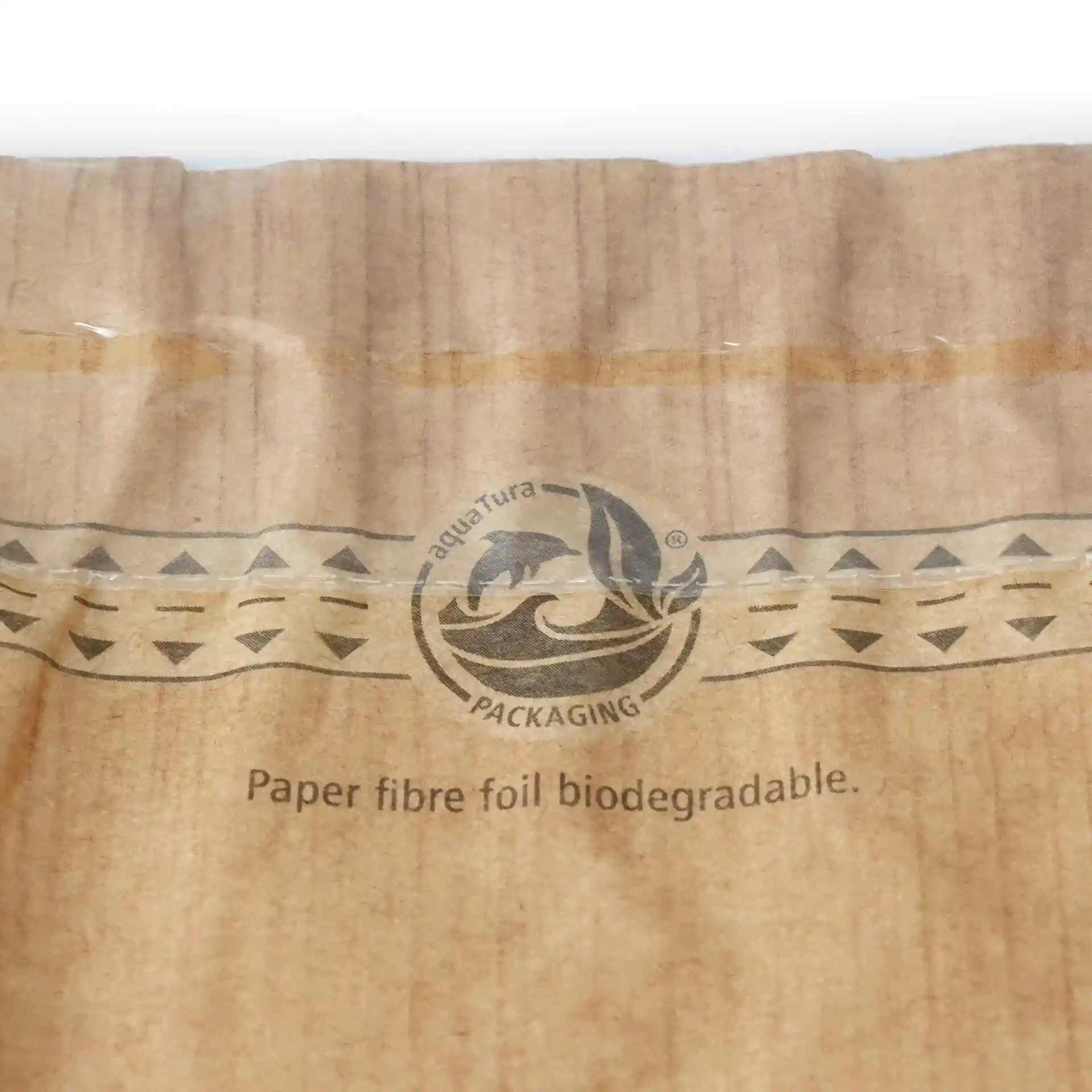 Close-up of a printed paper snack bag with a palm leaf design and a circular logo.