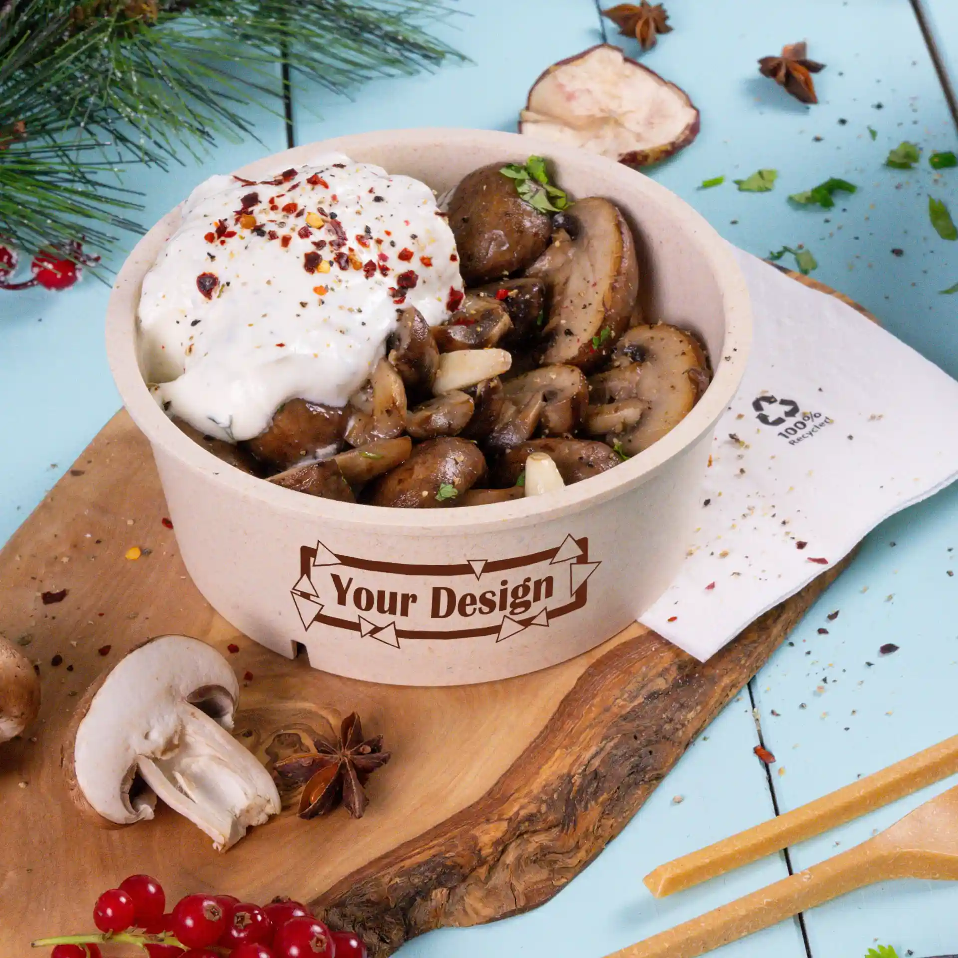Runde cremeweiße wiederverwendbare Schüssel mit sautierten Champignons und Sauerrahm, auf einem Holzbrett.