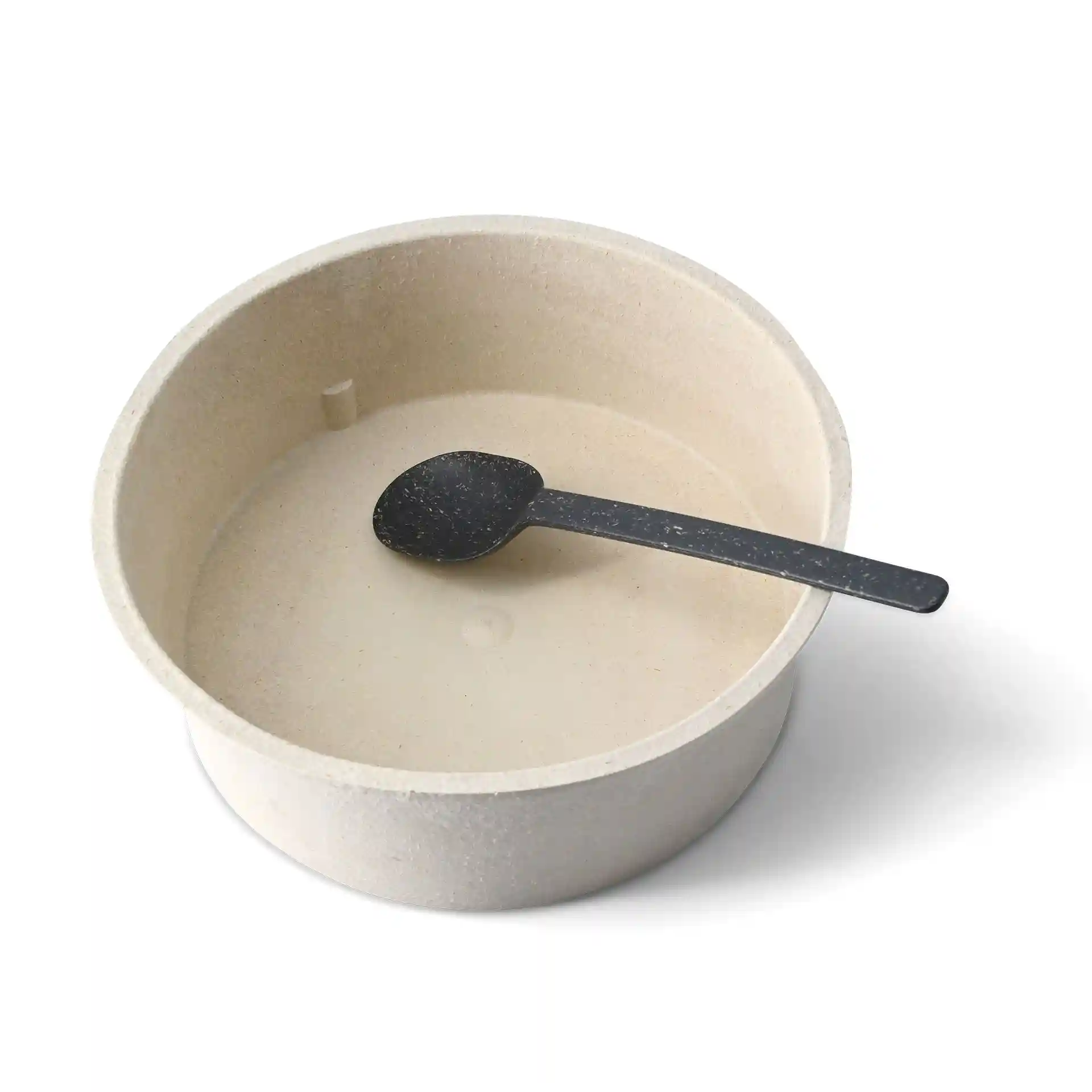 Schüssel aus einem hellen Bio-Material mit einem schwarzen wiederverwendbaren Löffel darin.