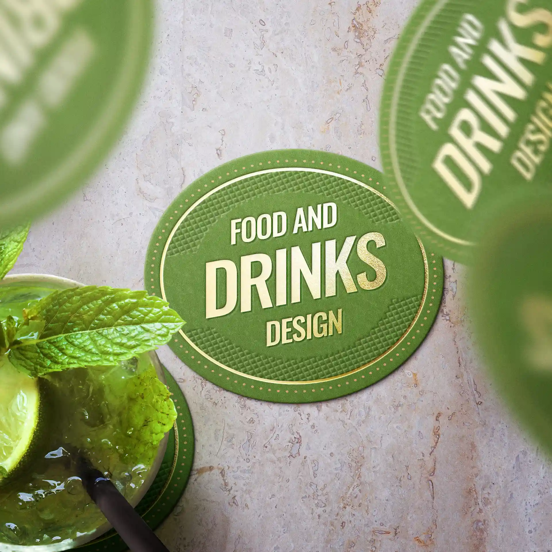 Oval green drink coaster with text design, featuring a mint leaf and lime slice beside a beverage.