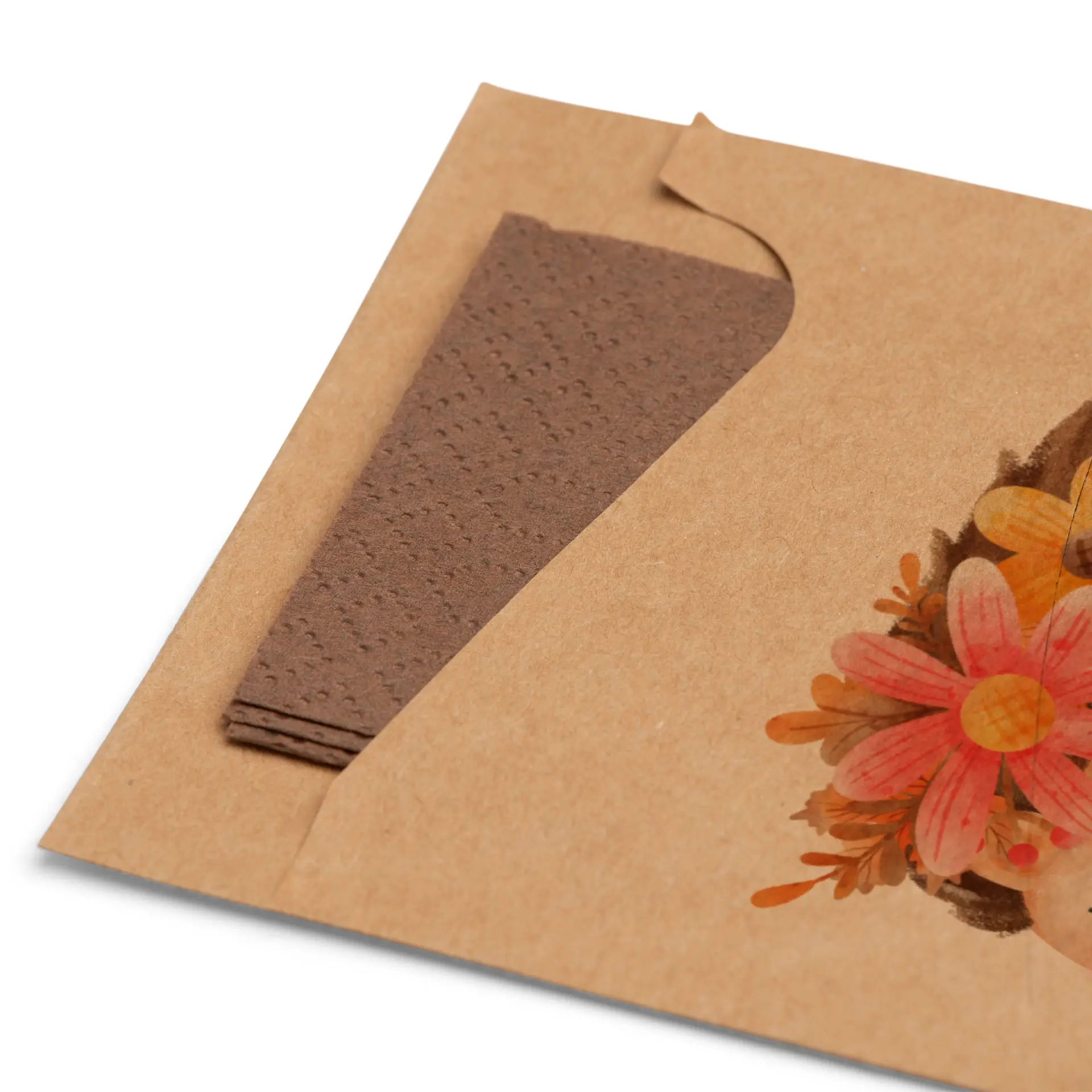 Brown kraft cutlery sleeve with folded brown napkin displayed partially inside, featuring floral design on the front.