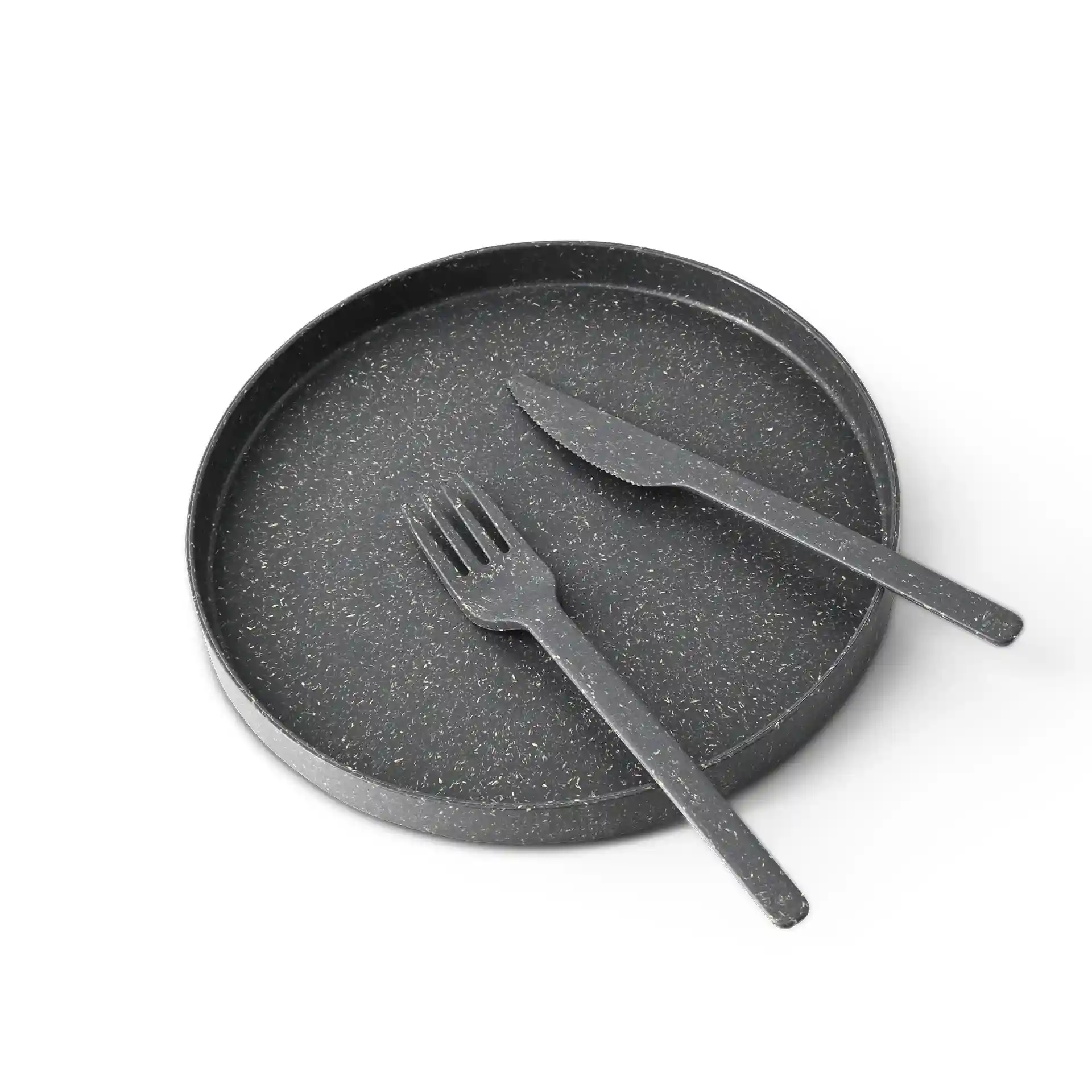 Black round tray with a textured surface, accompanied by a black knife and fork made from bio compound material.