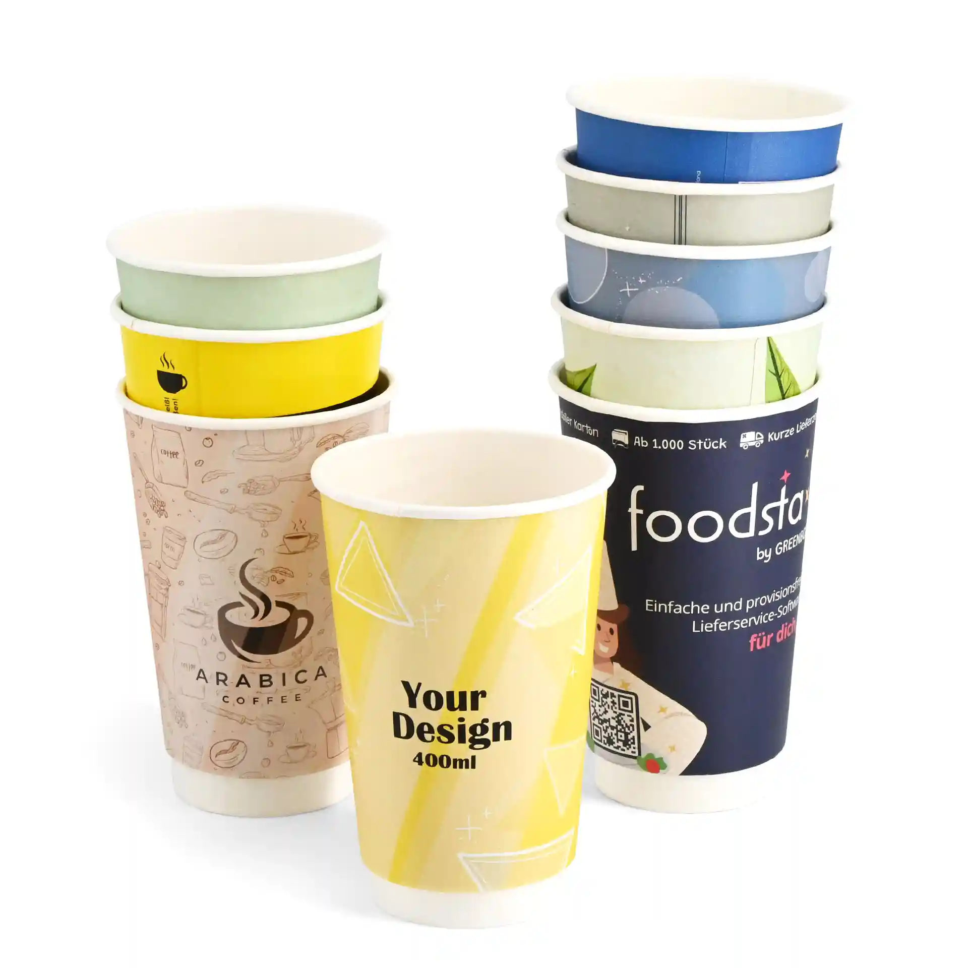 Stack of custom printed paper cups in various designs, including a yellow cup with "Your Design" and an Arabica coffee design.