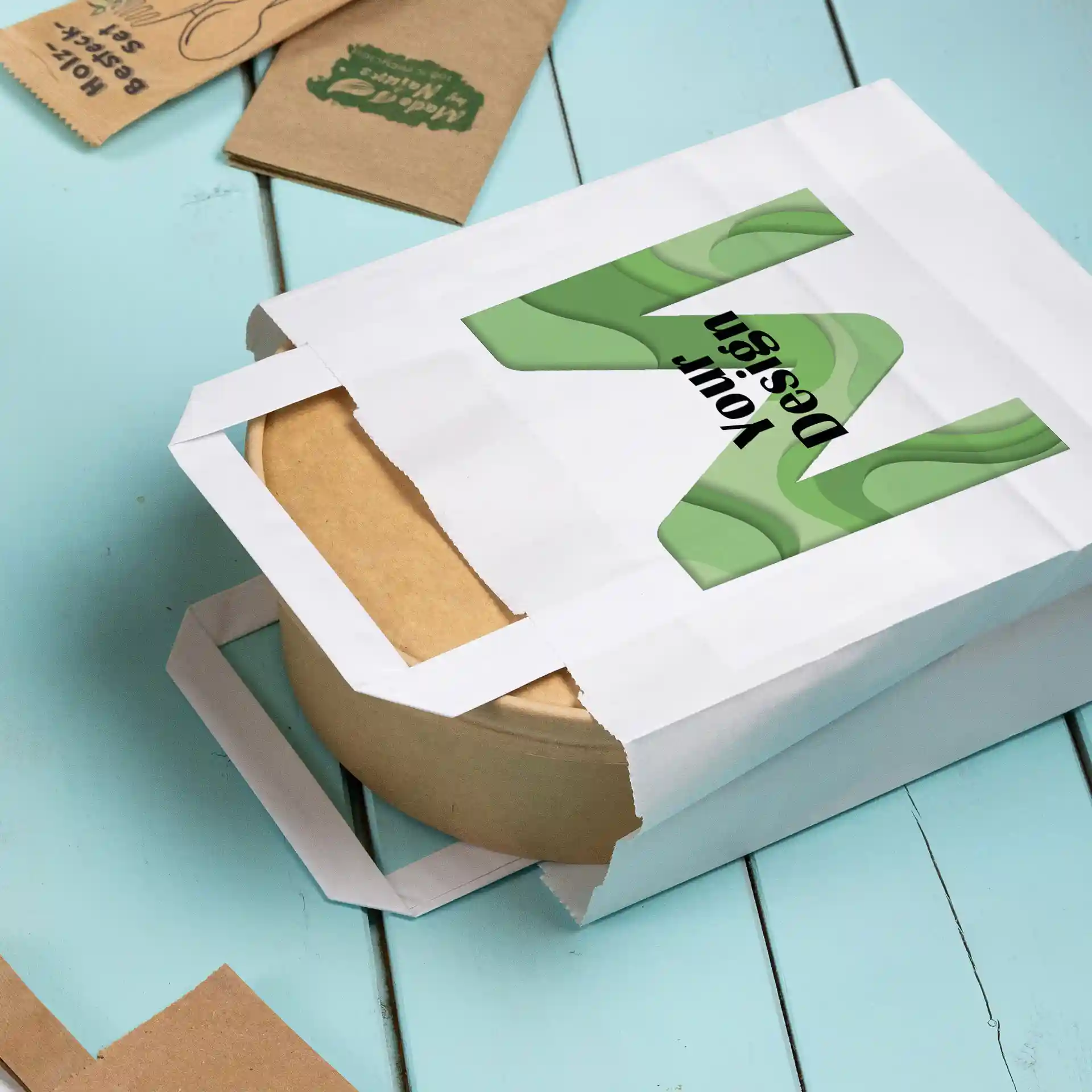 Weiße Papiertasche in rechteckiger Form mit einem braunen runden Behälter innen und einem Design auf der Vorderseite.