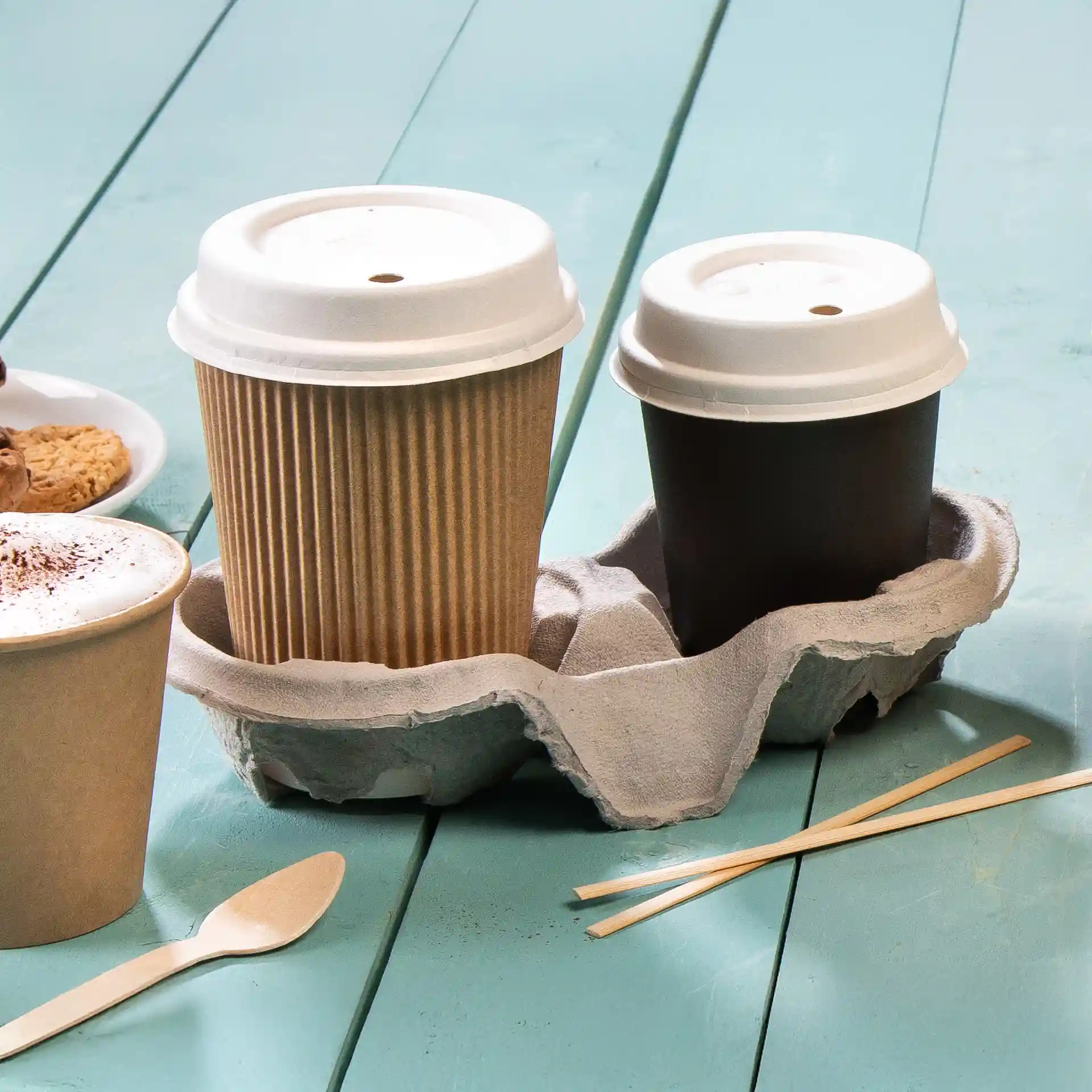 Image of a double cardboard cup holder with two cups, one brown and one kraft, on a light blue surface.