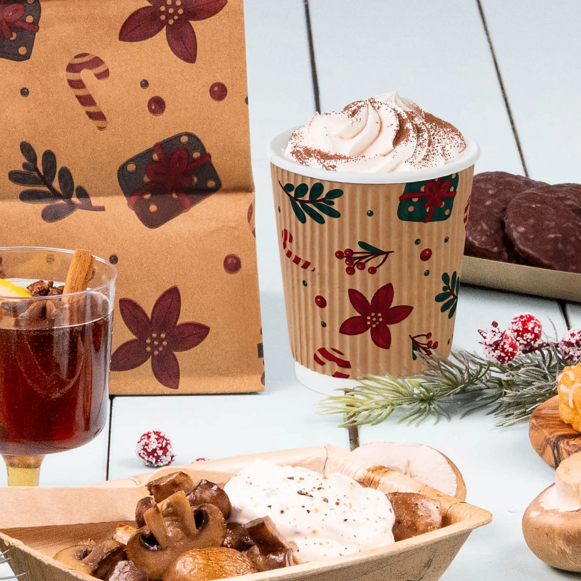 Bild eines 200 ml braunen Bechers mit Winterdesign, gefüllt mit Schlagsahne, neben verschiedenen festlichen Snacks.