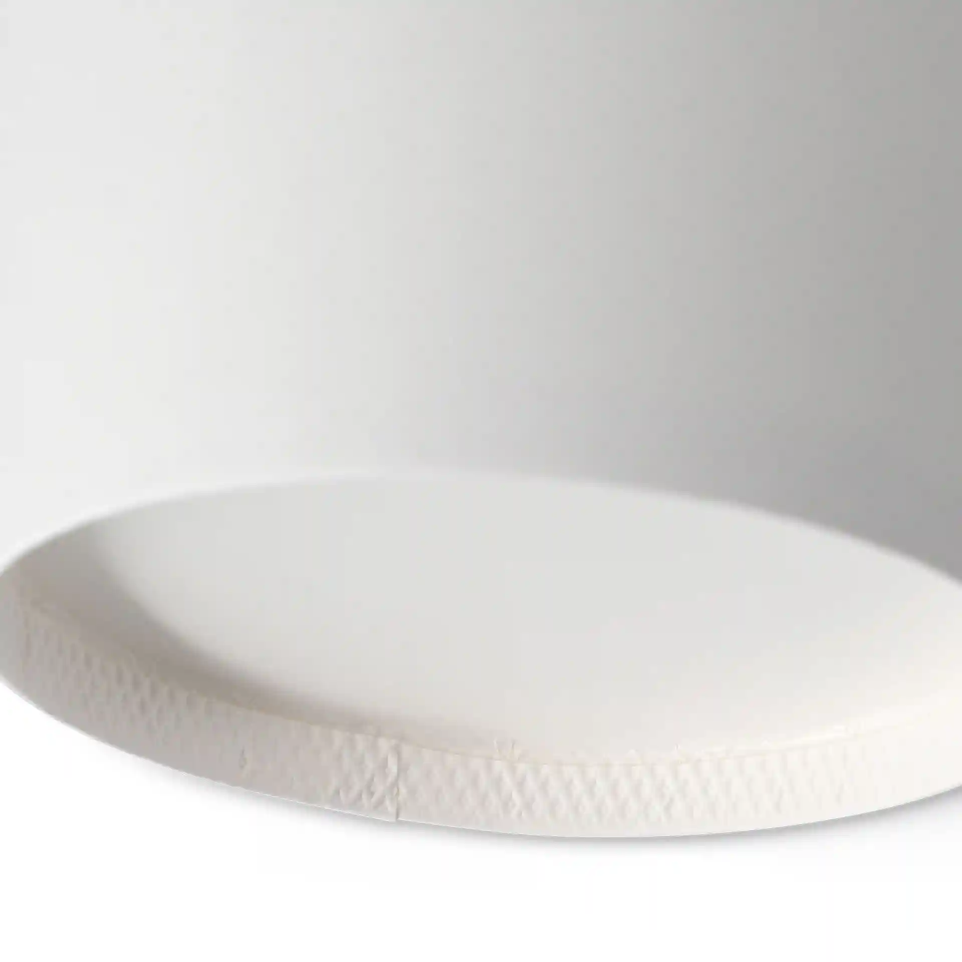 White cardboard soup cup with a round base, featuring a textured edge, shown from a low angle.