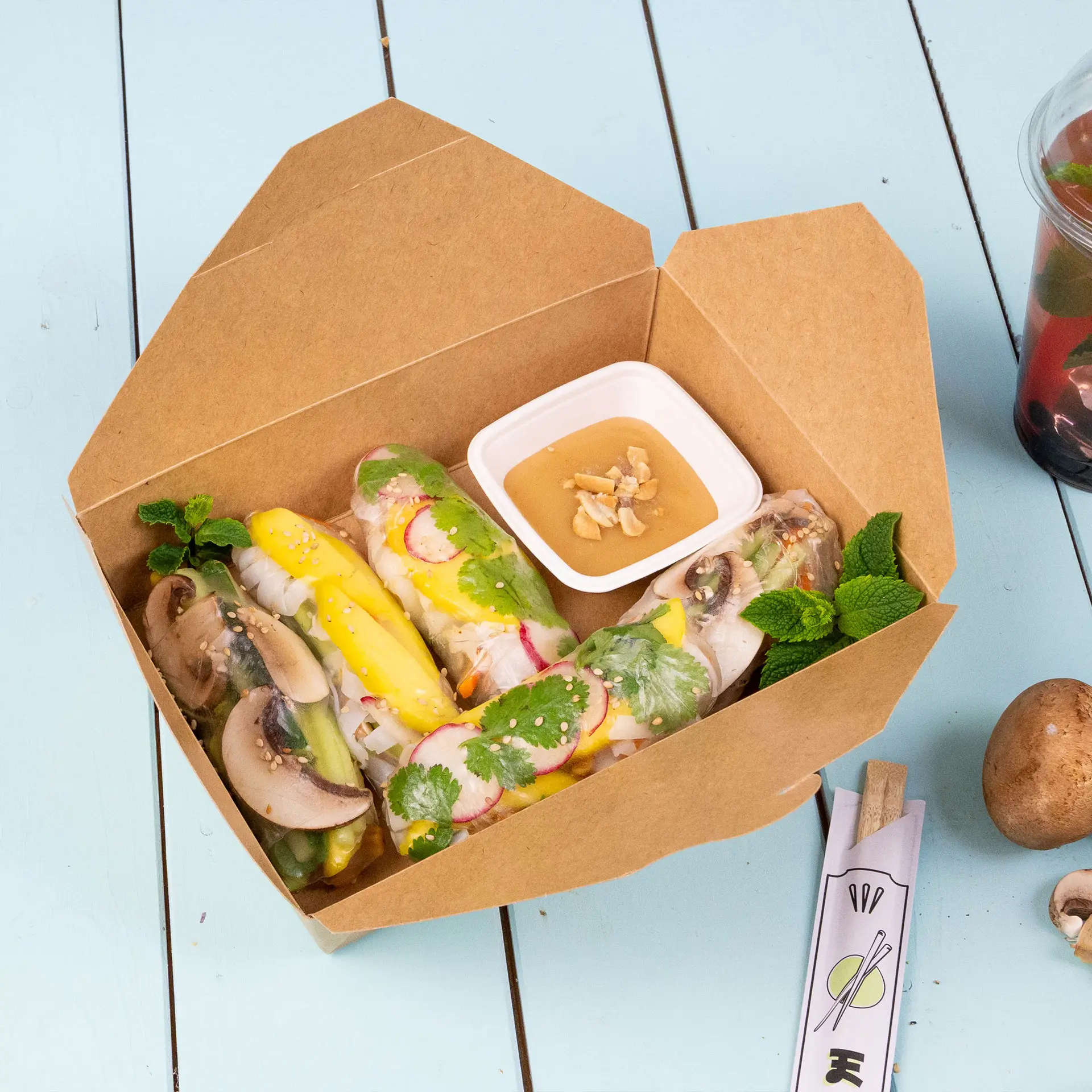Takeaway food packaging in brown, 1100 ml size; includes various boxes and a sauce container on a blue surface.