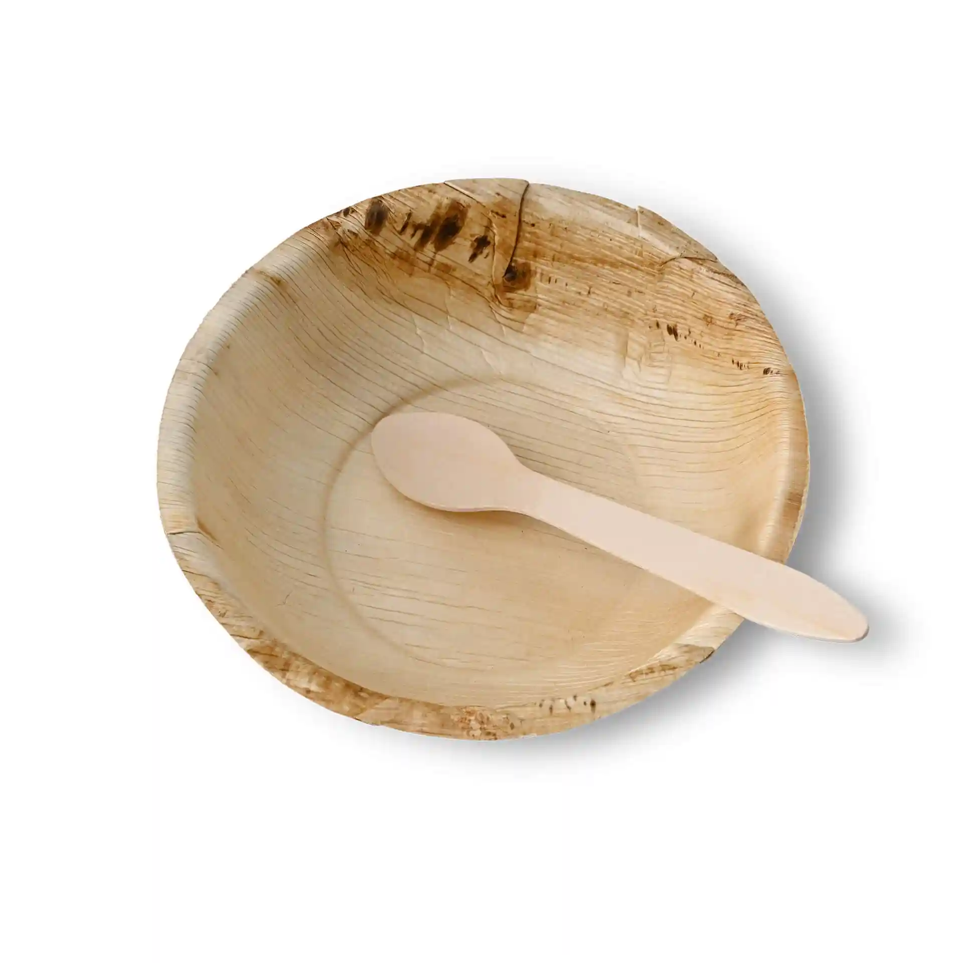 Round palm leaf bowl with a wooden spoon resting inside, showing a natural grain texture.