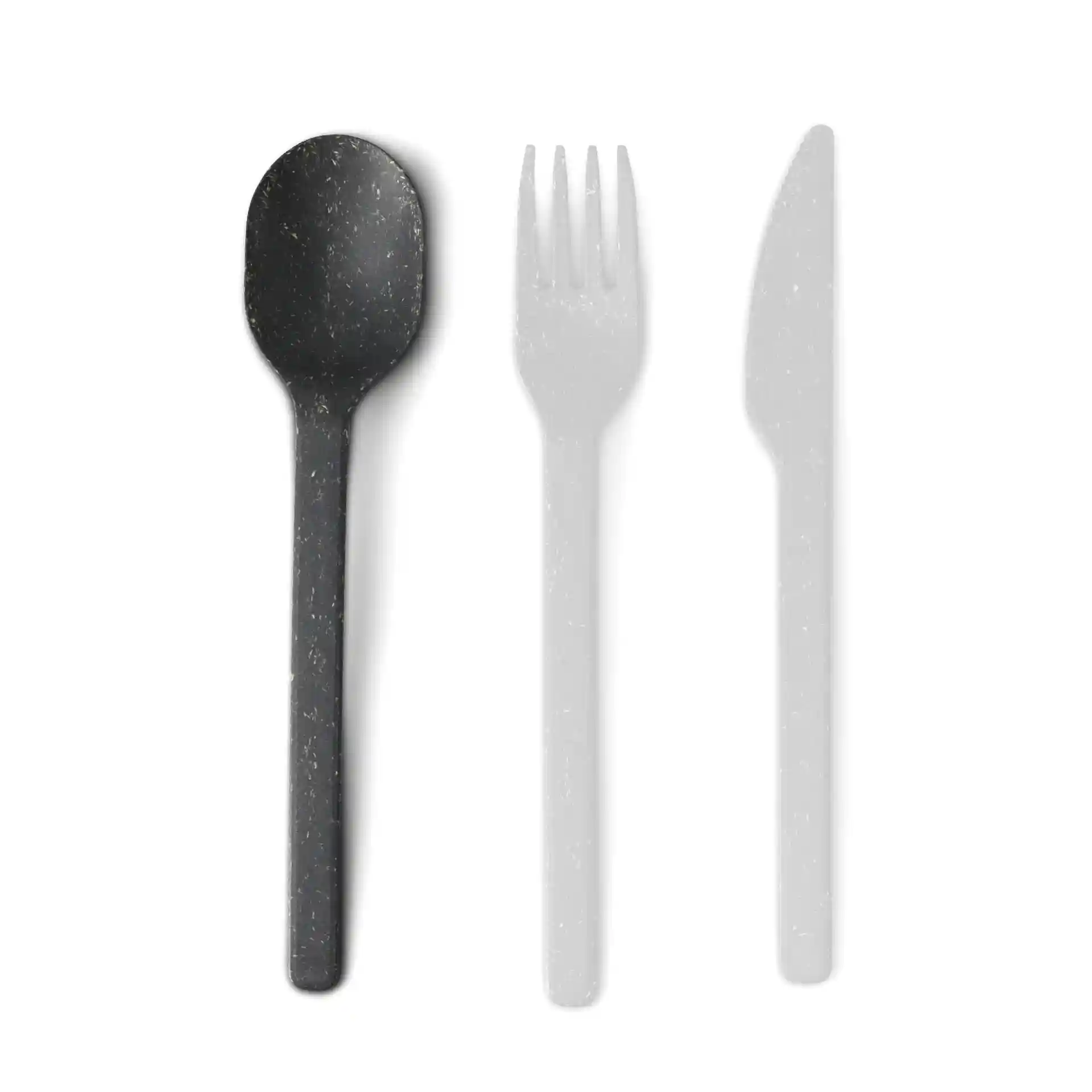 Black reusable spoon with a smooth surface, alongside a fork and knife in faded visibility.