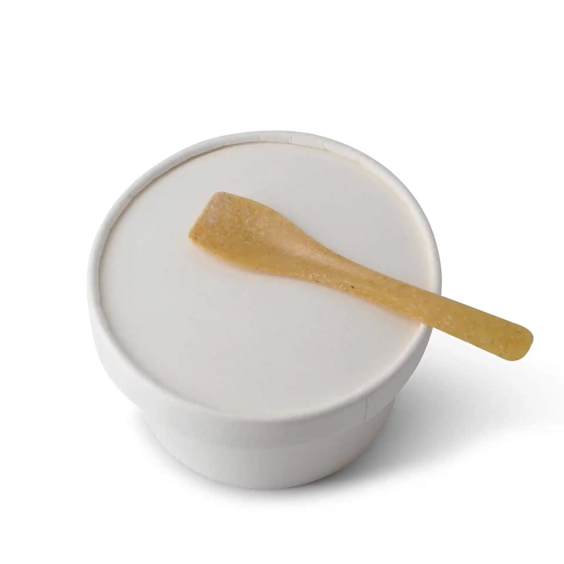 Brown reusable ice cream spoon resting on a white container lid.
