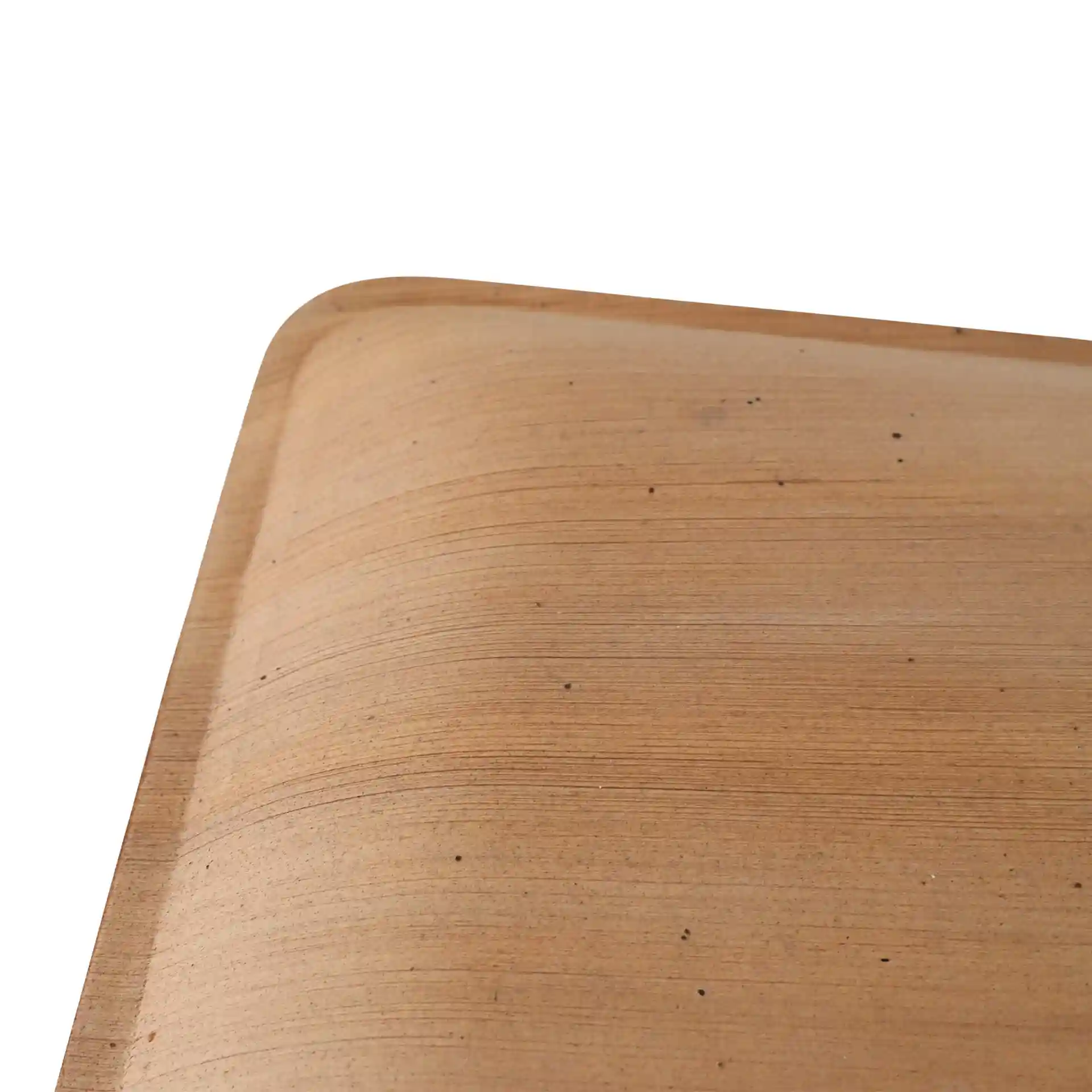 Close-up of a square palm leaf plate with a grain texture and rounded edges.