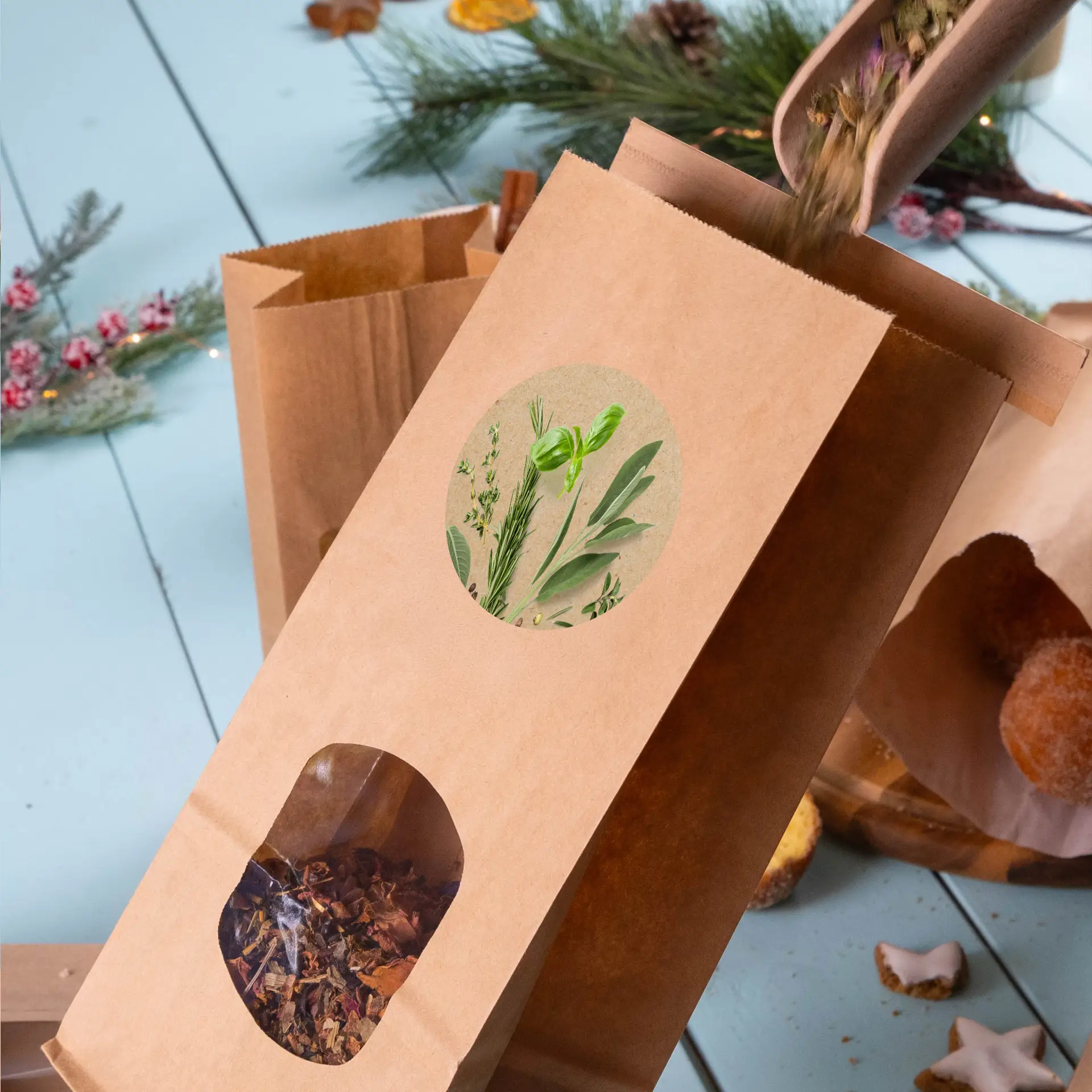 Kraft paper bag with a window showing tea leaves, and a round label featuring plant illustrations.