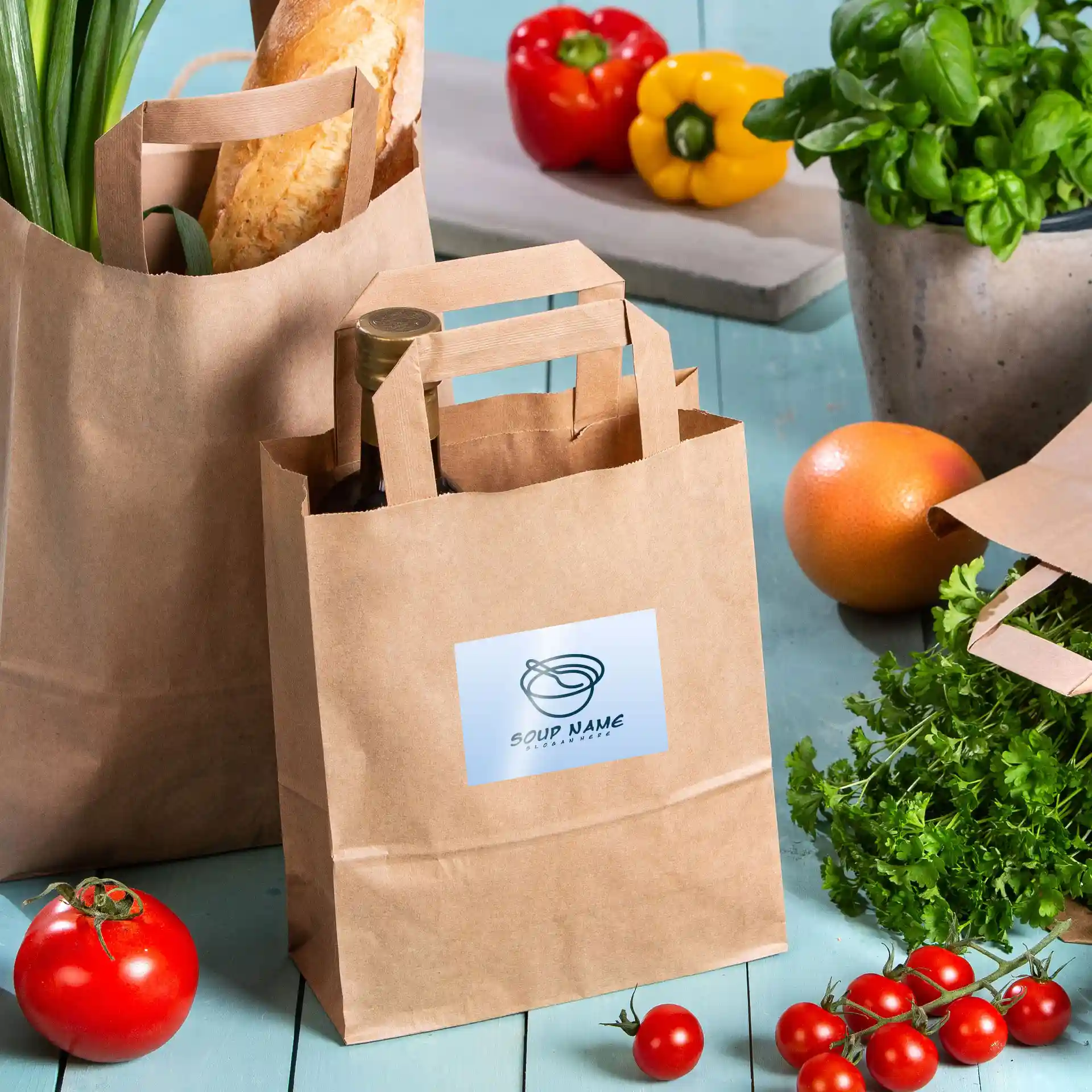 Brown paper bags with handles, one containing a bottle, surrounded by vegetables and herbs on a blue surface.