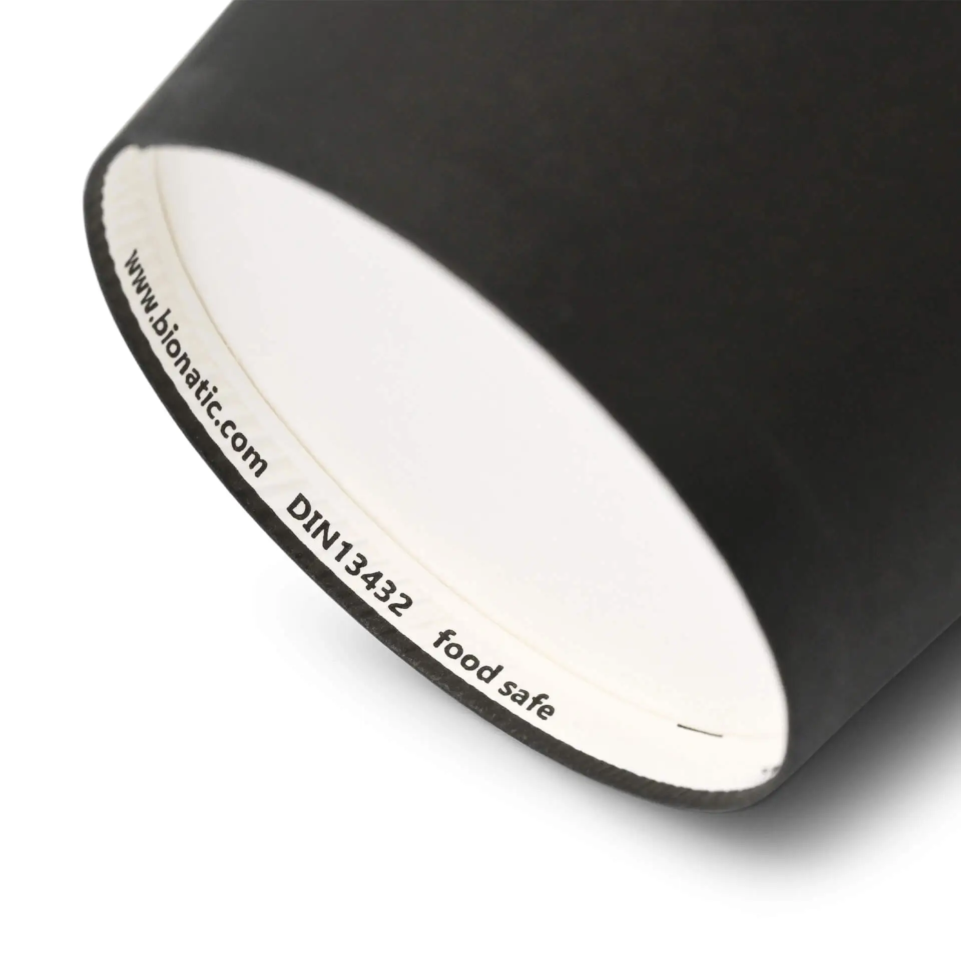 Black paper cup with a white interior, showing a label with markings on the rim.