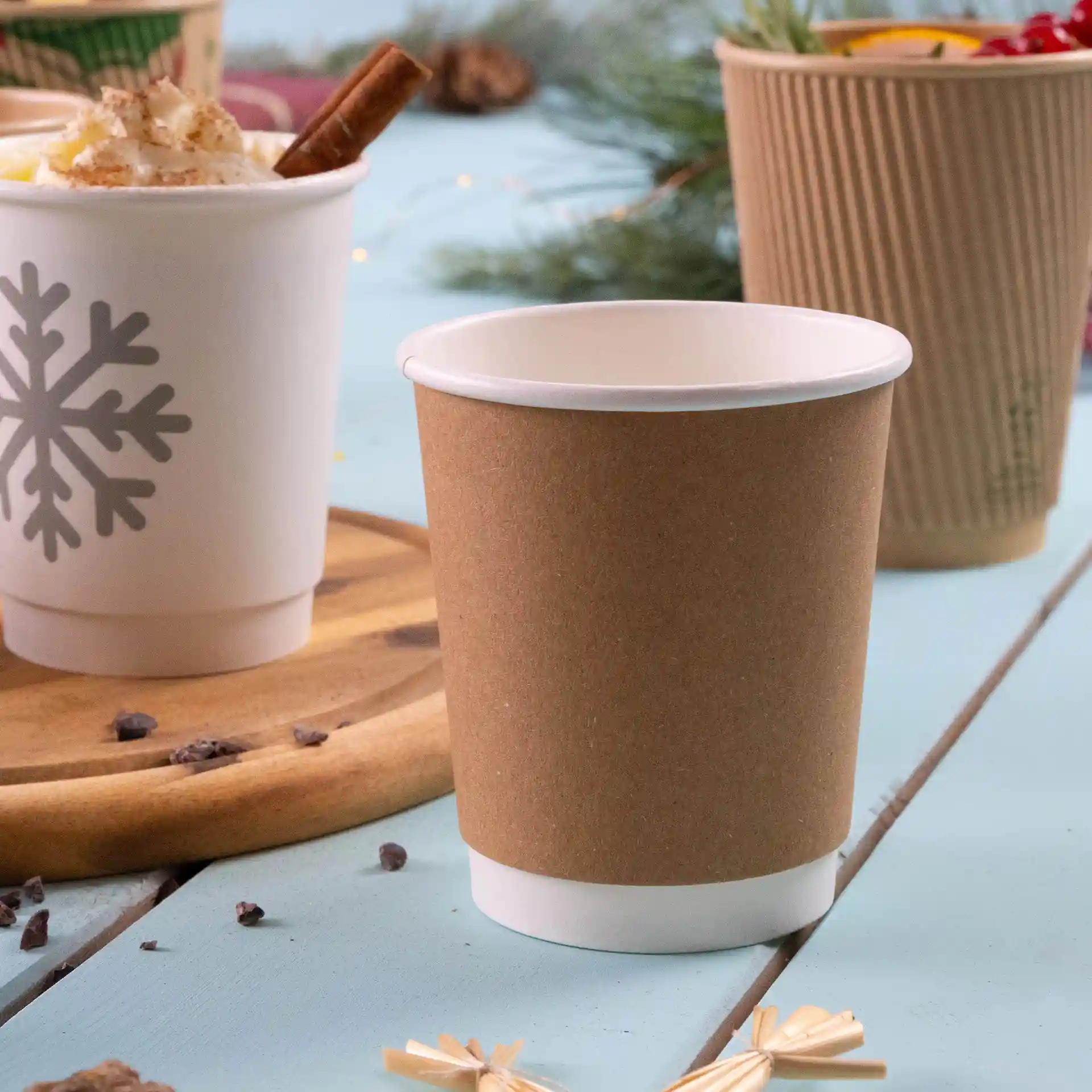 Brauner doppelwandiger Becher mit weißem Innenraum, 200 ml, auf einer Holzoberfläche mit anderen Bechern im Hintergrund.