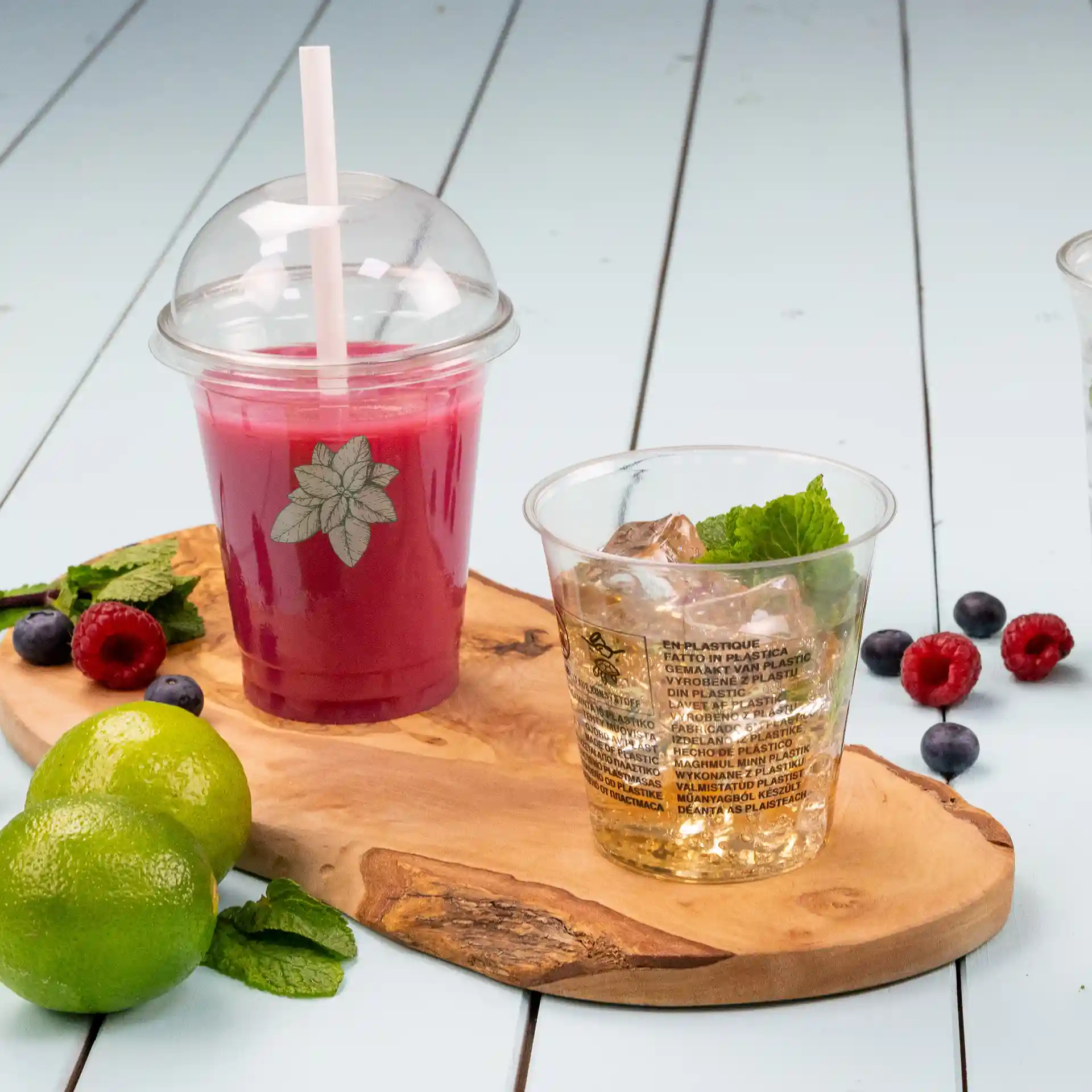 Clear 12 oz rPET cup with a dome lid and straw, filled with a red beverage, alongside a cup of ice and mint.