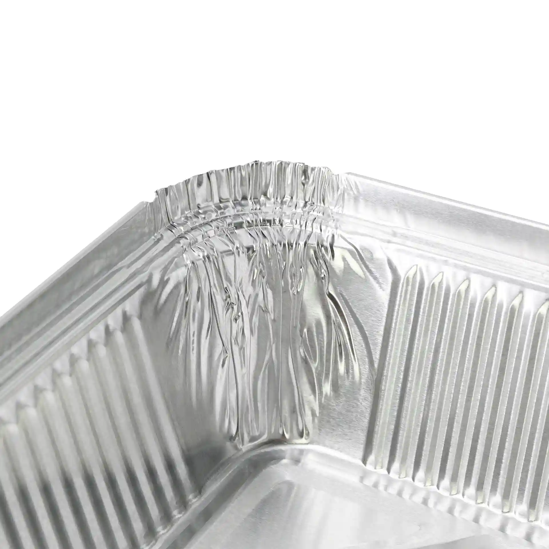 Nahaufnahme der Ecke eines rechteckigen Aluminiumbehälters mit sichtbaren gekrümmten Kanten.