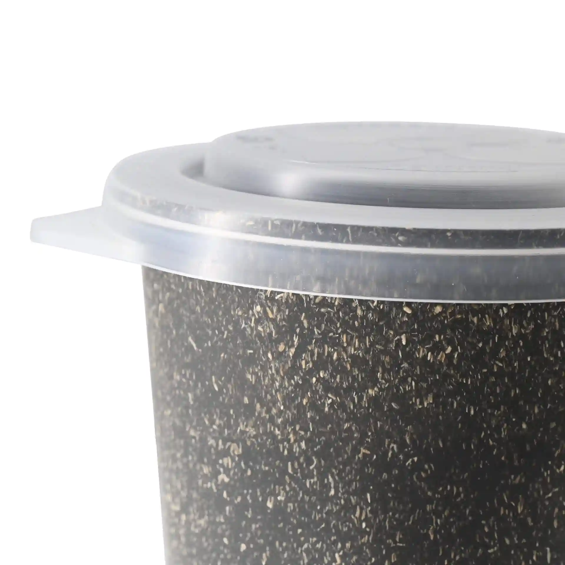 Close-up of a round cup with a textured black surface and a transparent lid.
