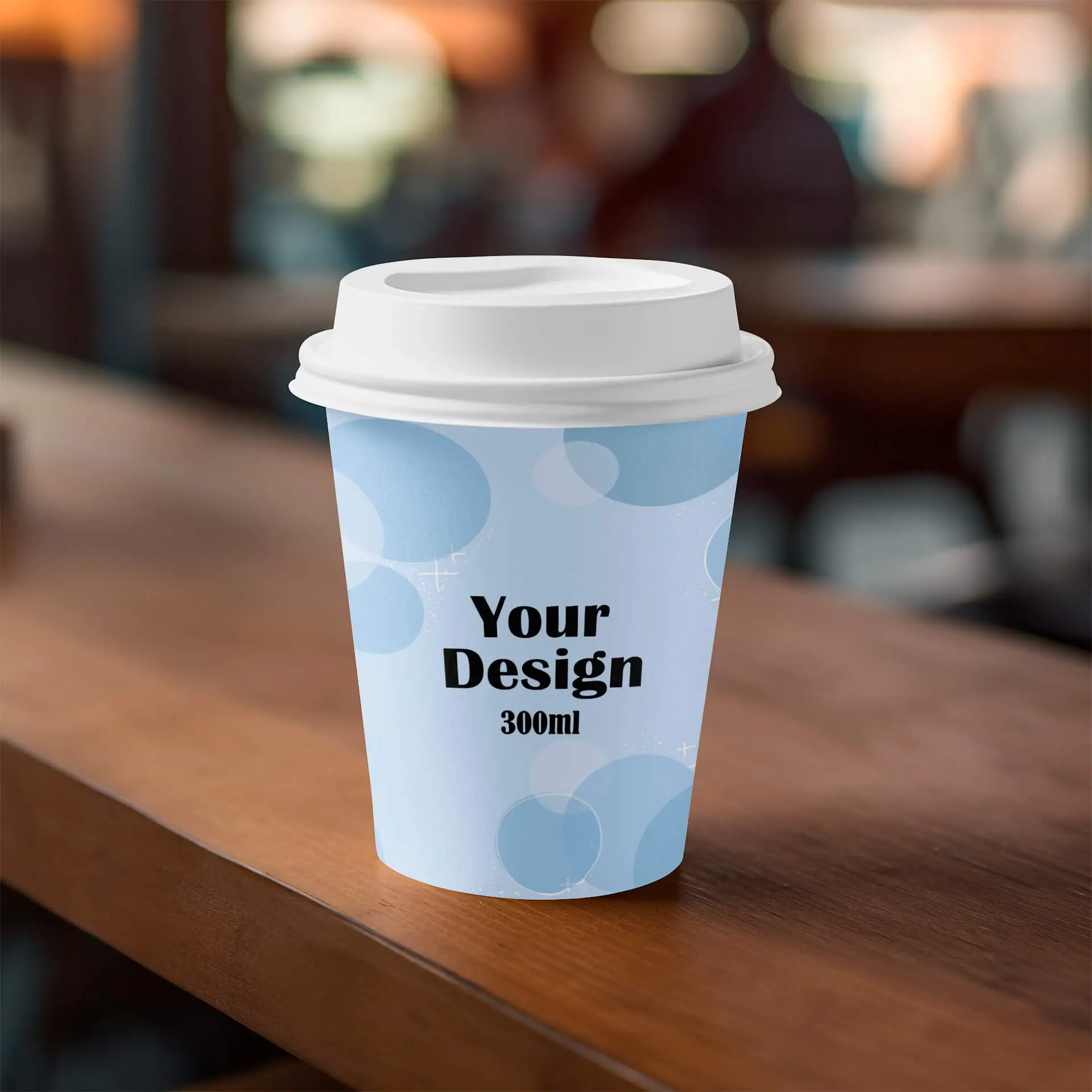 Einwandige Papiertassen mit blauem Design, beschriftet mit "Dein Design" und 300ml Volumen auf einer Holzoberfläche.
