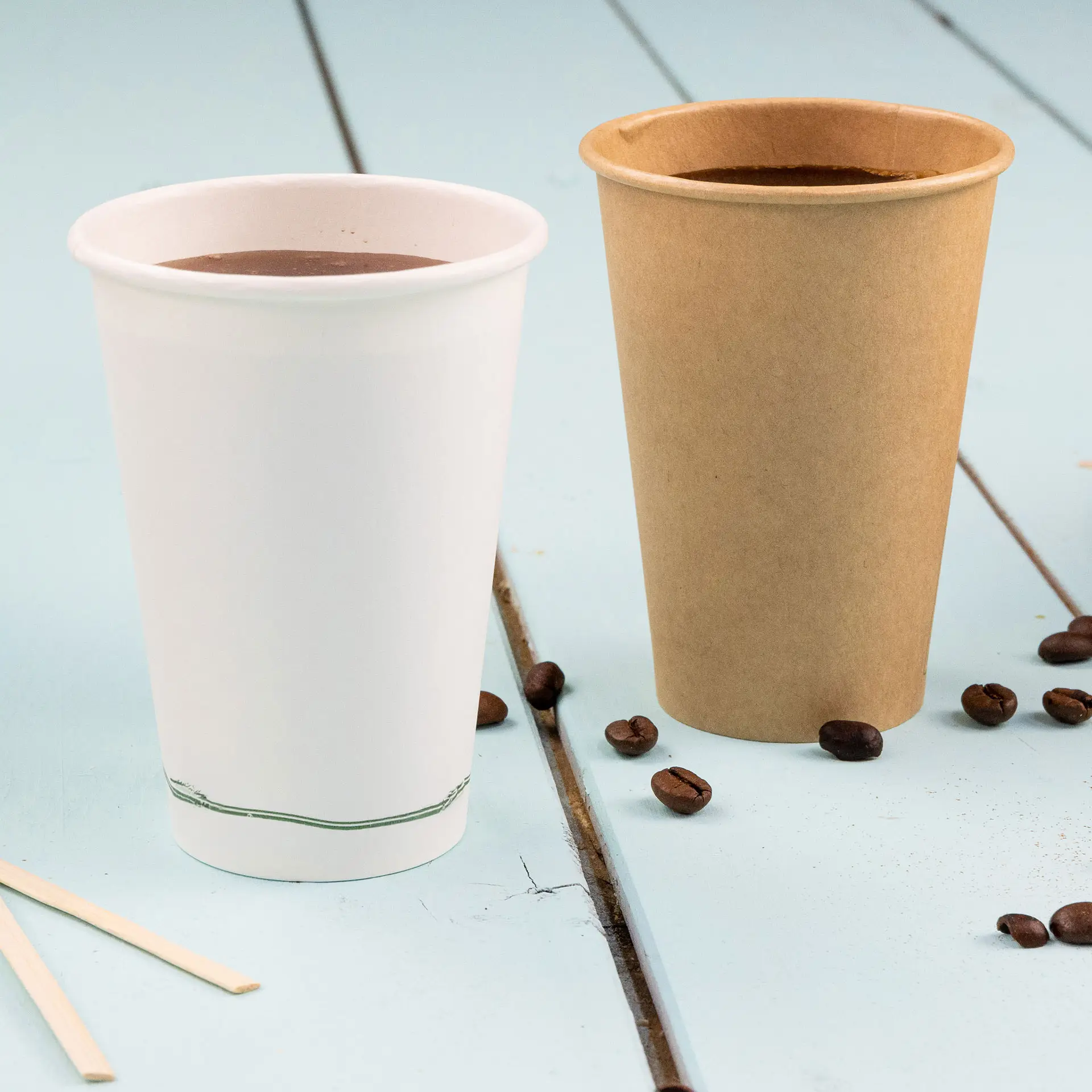 Image of two disposable cups: a white single wall cup with a green line at the base and a brown PLA-coated cup, both filled with liquid.