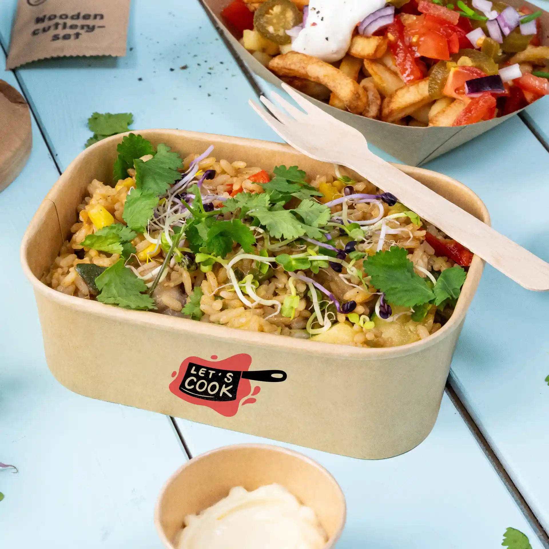 Rectangular brown salad bowl with rice, topped with cilantro and sprouts, and a wooden fork, on a blue surface.