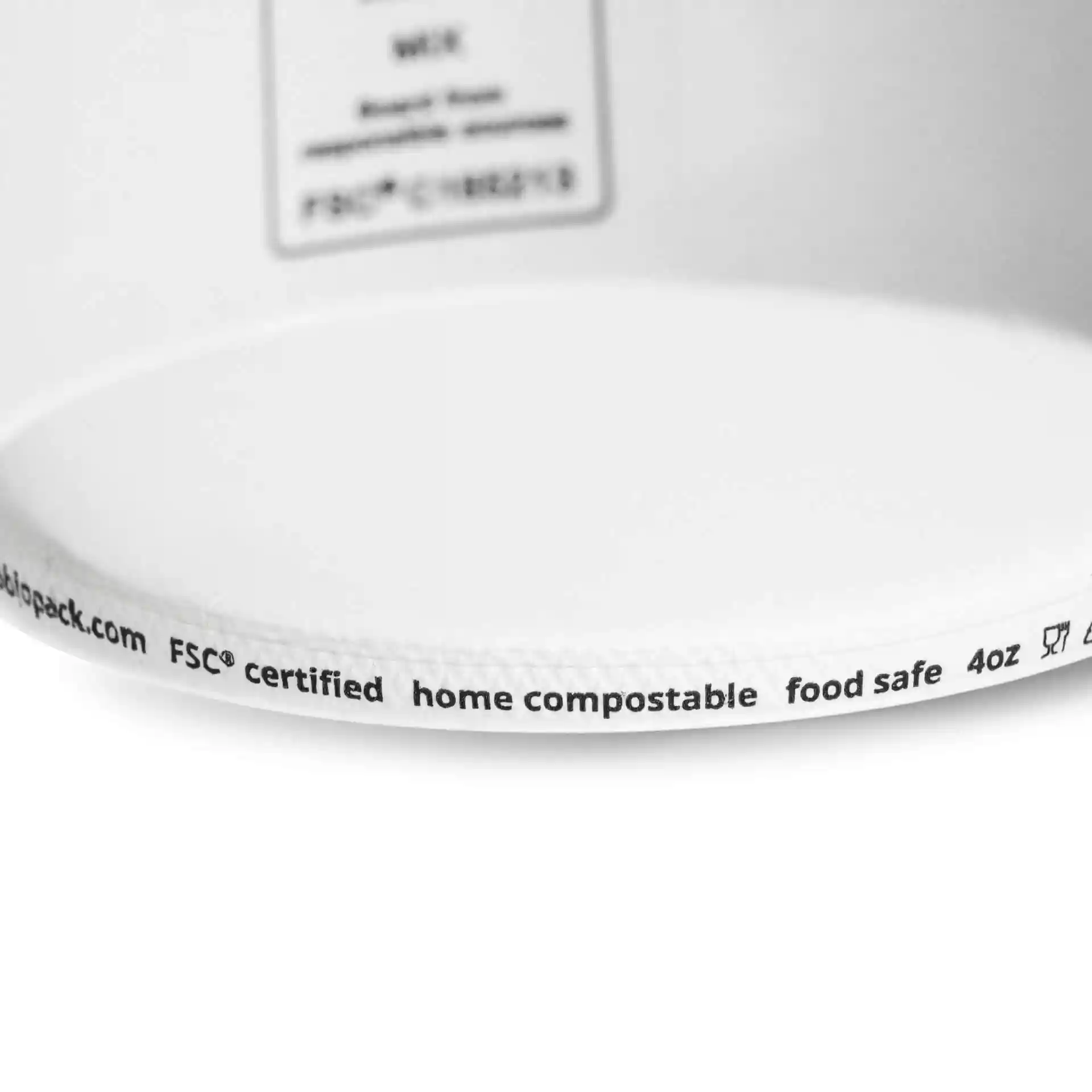 White cardboard cup with a round shape, showing a label with markings on the rim.
