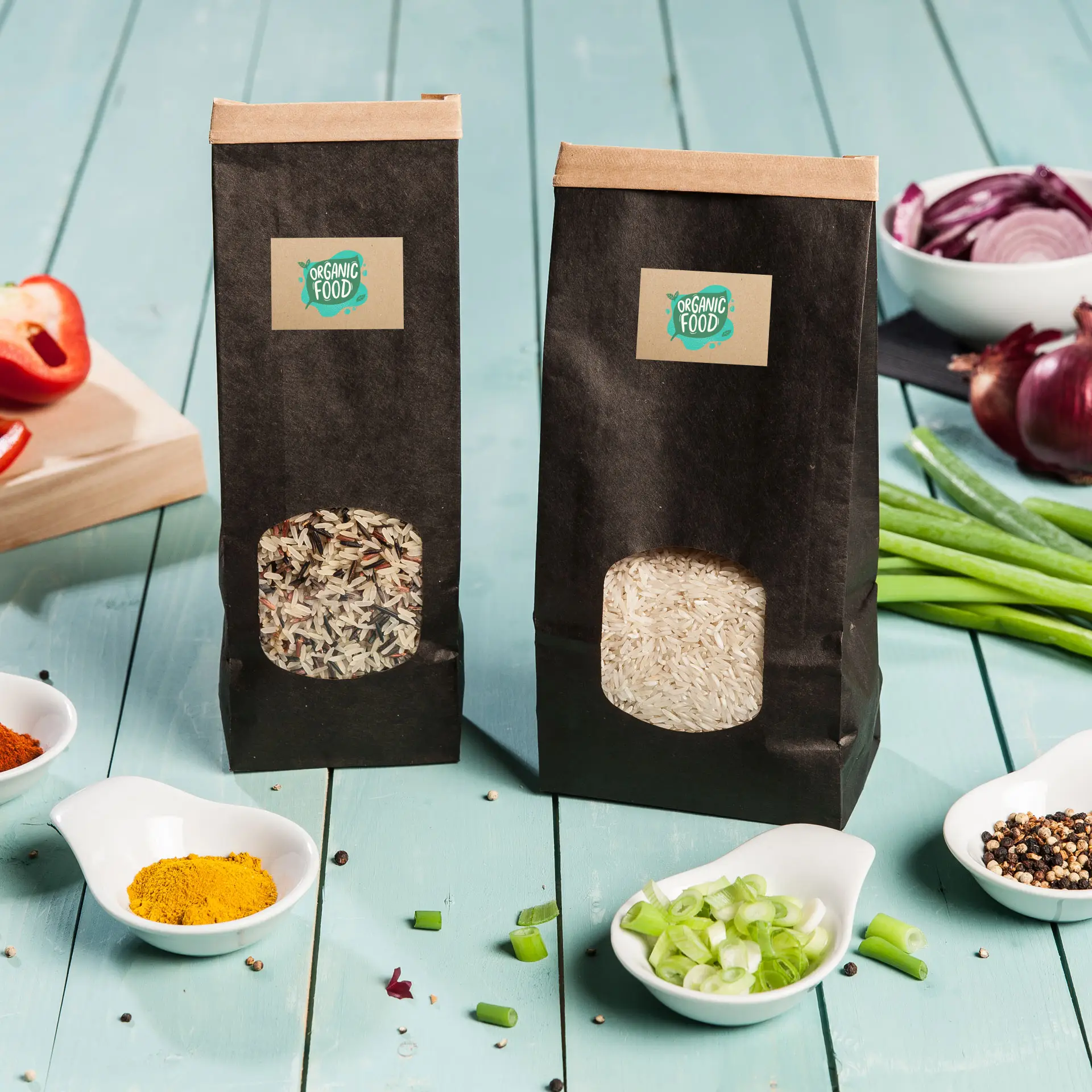 Two bags of rice on a wooden table, one with mixed grains and the other with white rice, surrounded by bowls of spices and vegetables.