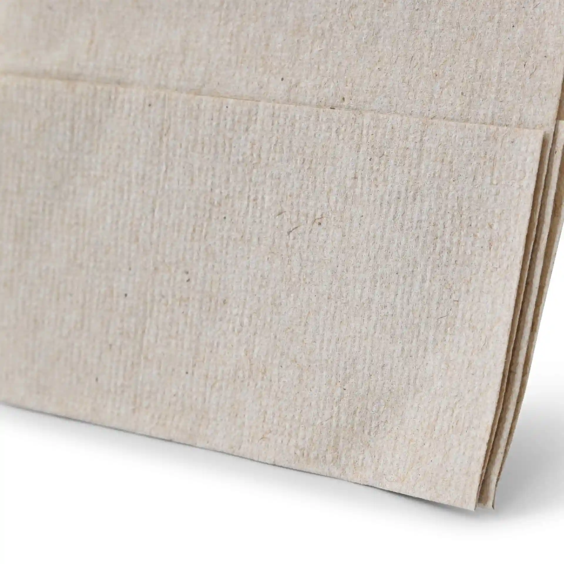 Nahaufnahme einer ungebleichten Papierserviette mit schwarzem Recycling-Symbol und dem Hinweis, dass sie zu 100 % recycelt ist.