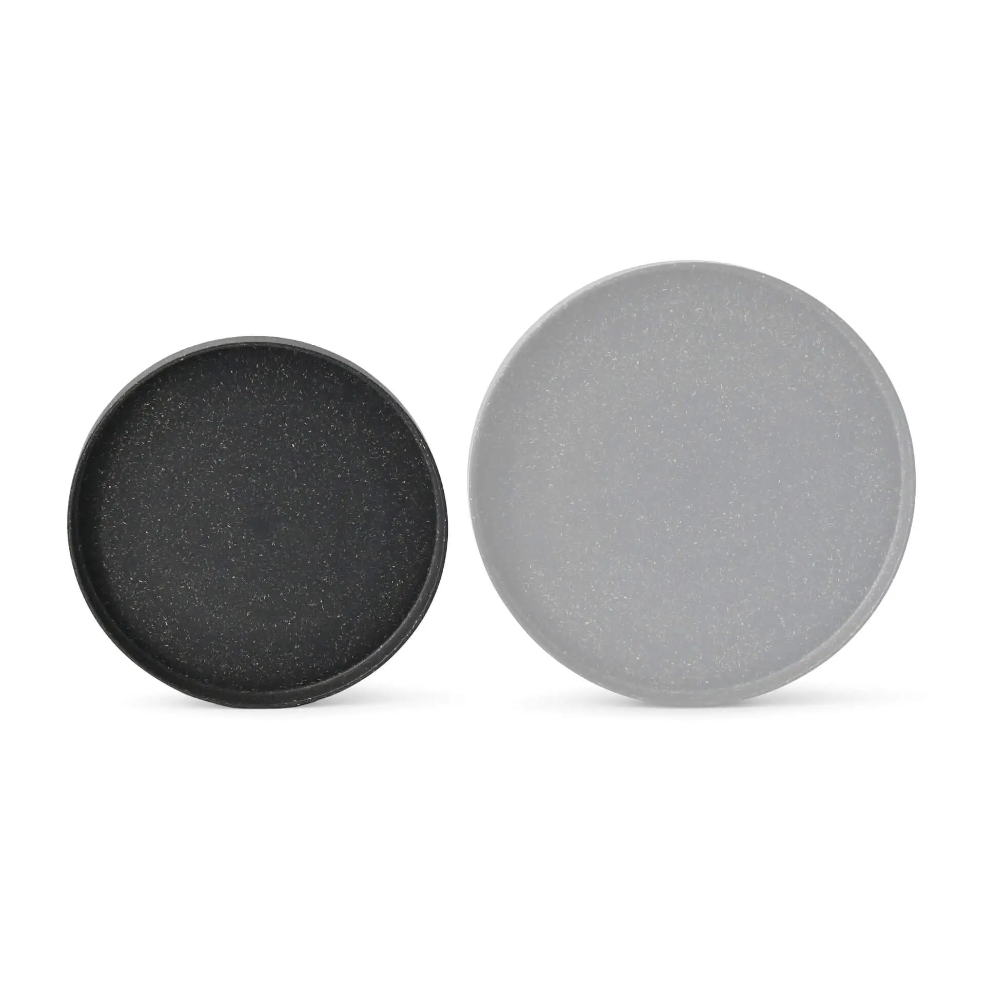 Two round reusable plates, one black and one grey, displayed side by side on a plain background.