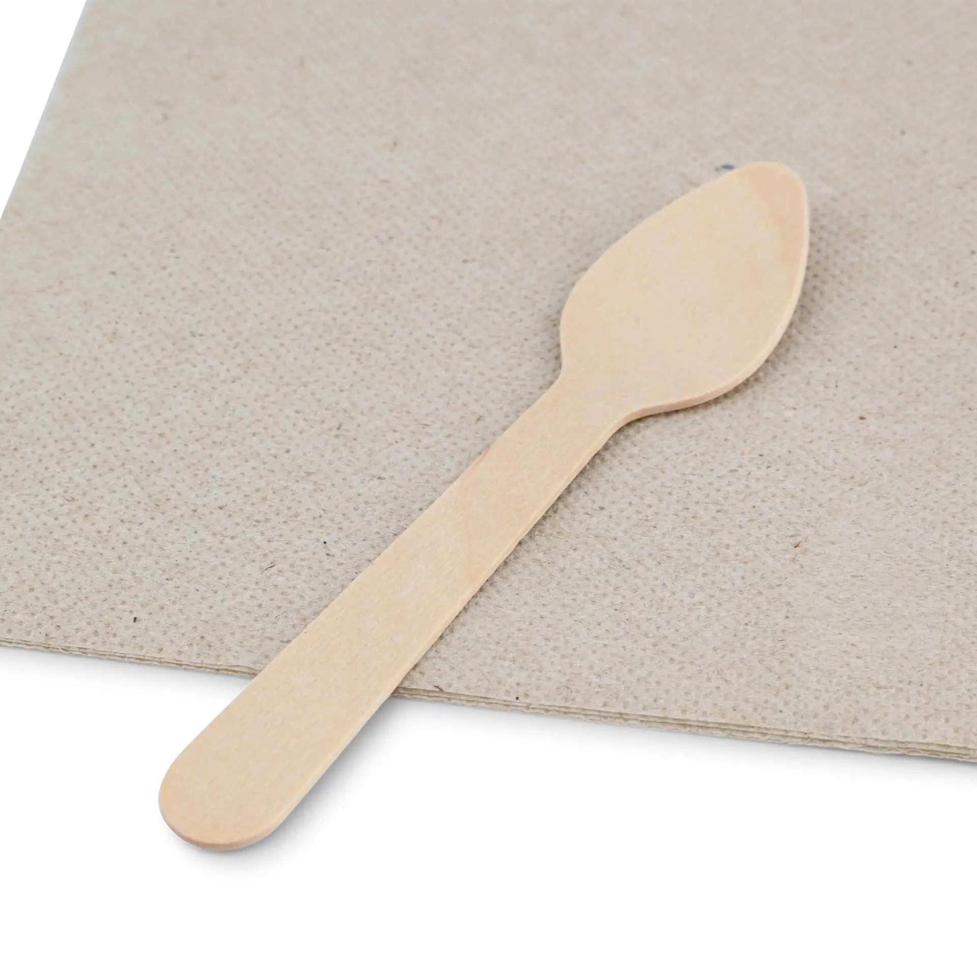 Wooden espresso spoon, 11 cm long, on a textured brown surface with a recycling symbol.