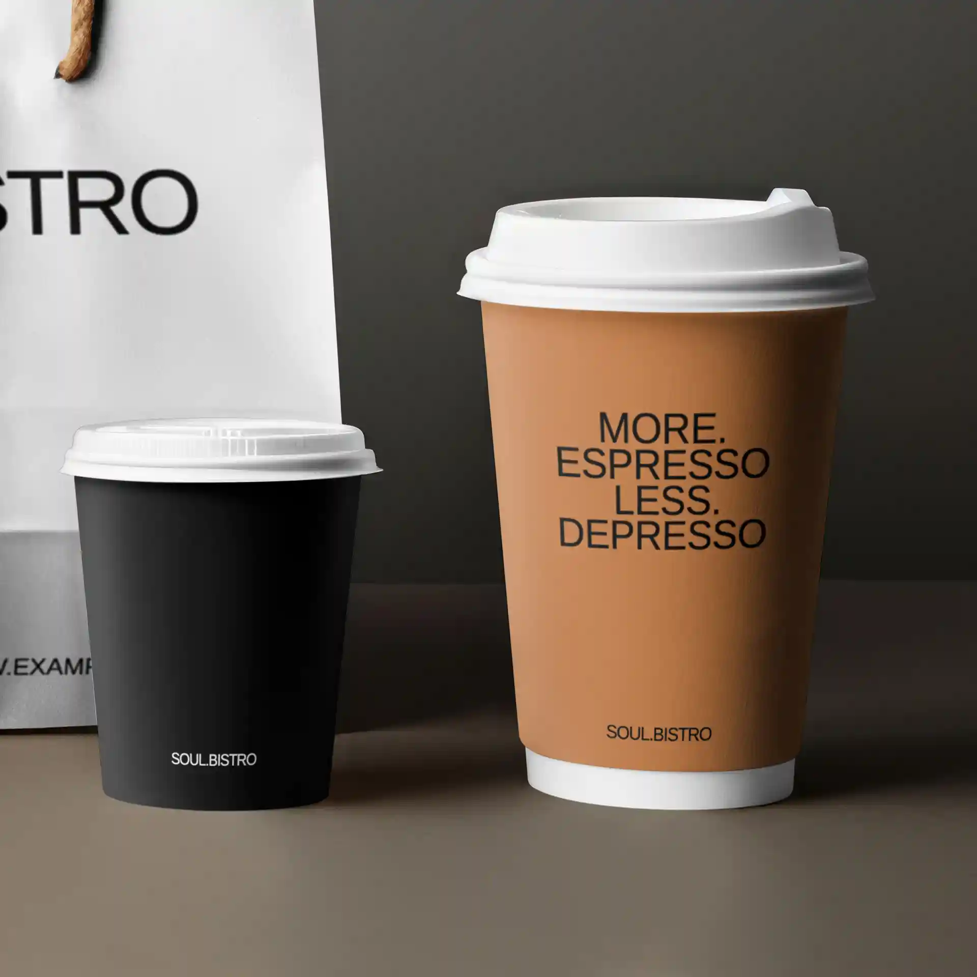 Bild von zwei Pappbechern, einem schwarzen und einem braunen, mit weißen Deckeln, auf einem schlichten Hintergrund.