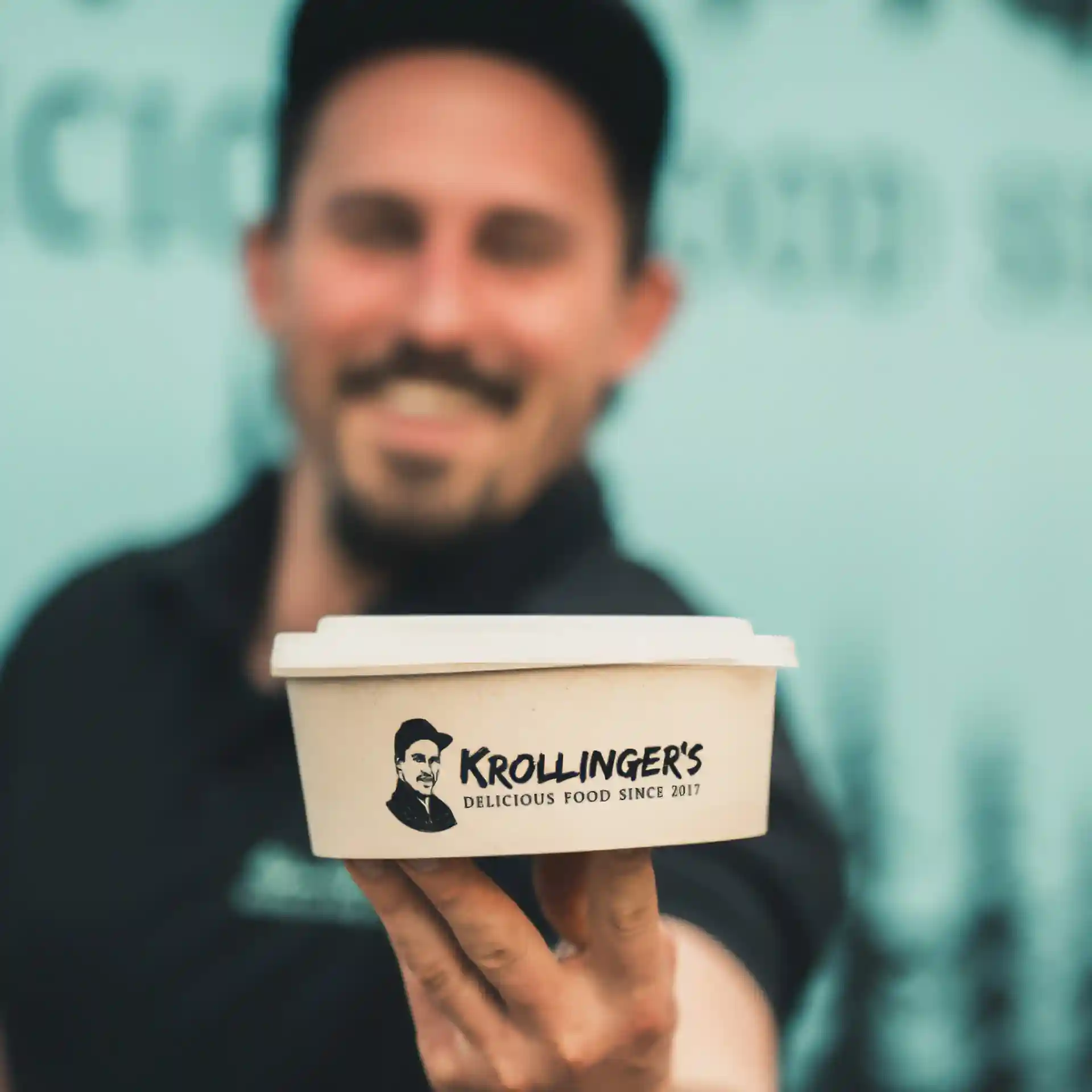 Round reusable bowl with a cream-white color, 650 ml capacity, held by a person in a blurred background.