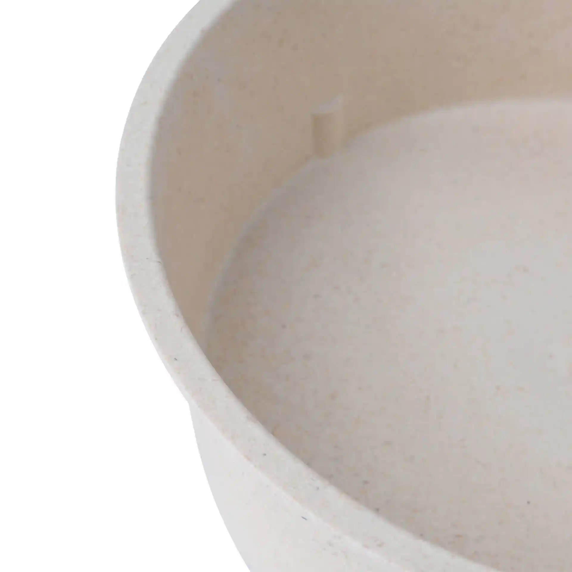 Close-up of a round cream white reusable bowl with a smooth interior and a small protrusion inside.