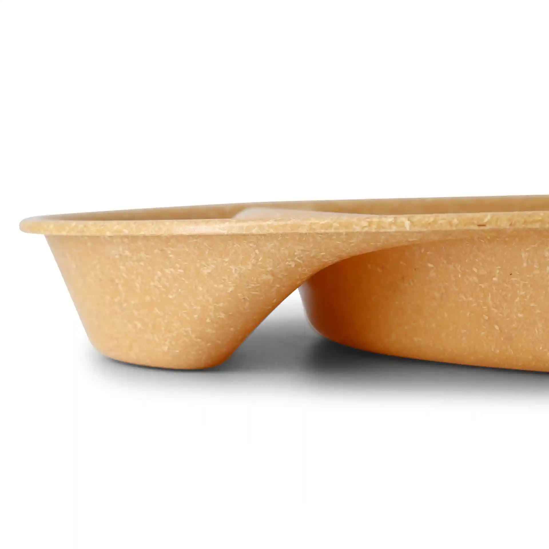 Side view of a brown reusable divided plate with two compartments, made of bio compound material.