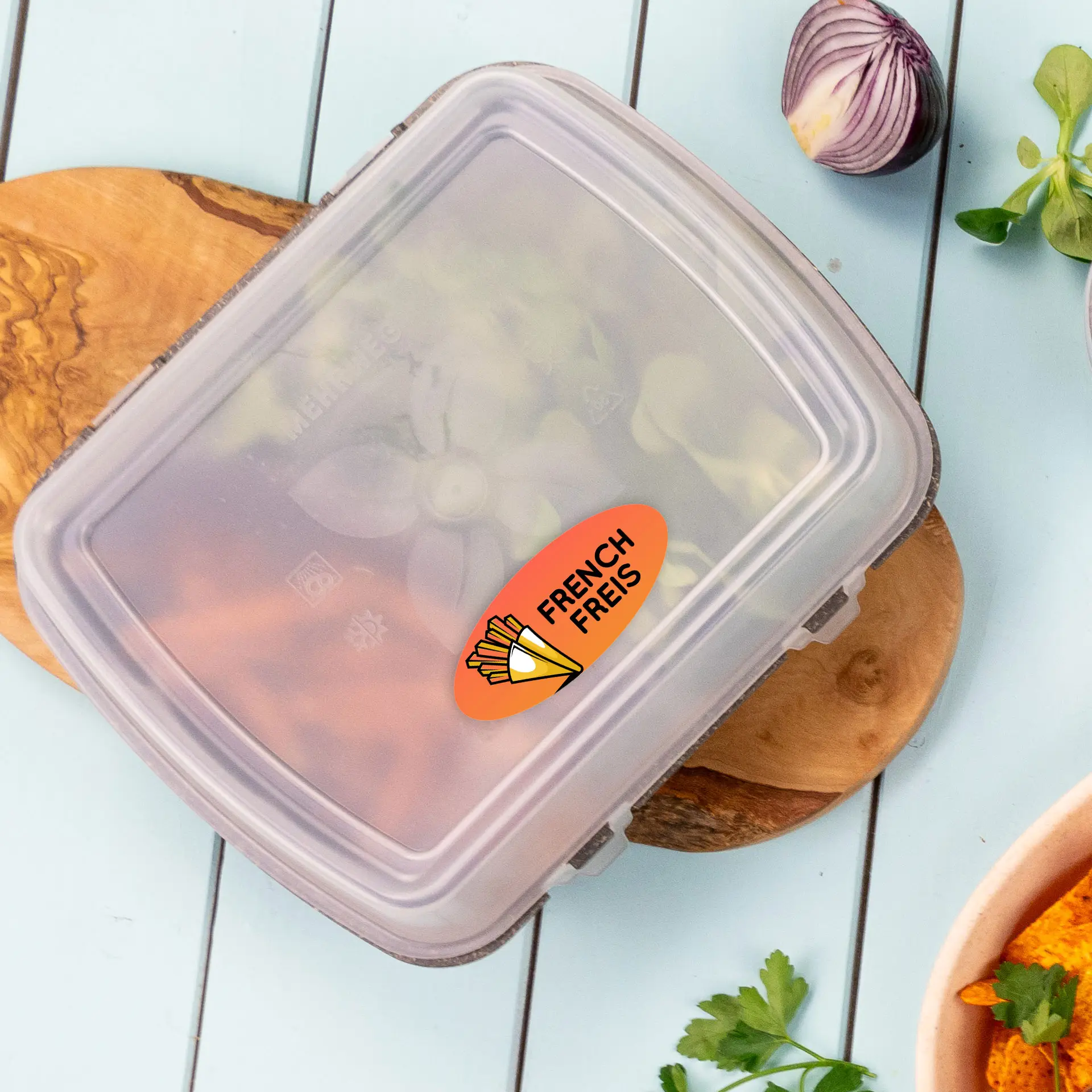 Container with a transparent lid holding various vegetables, featuring a round label that says "French Fries."