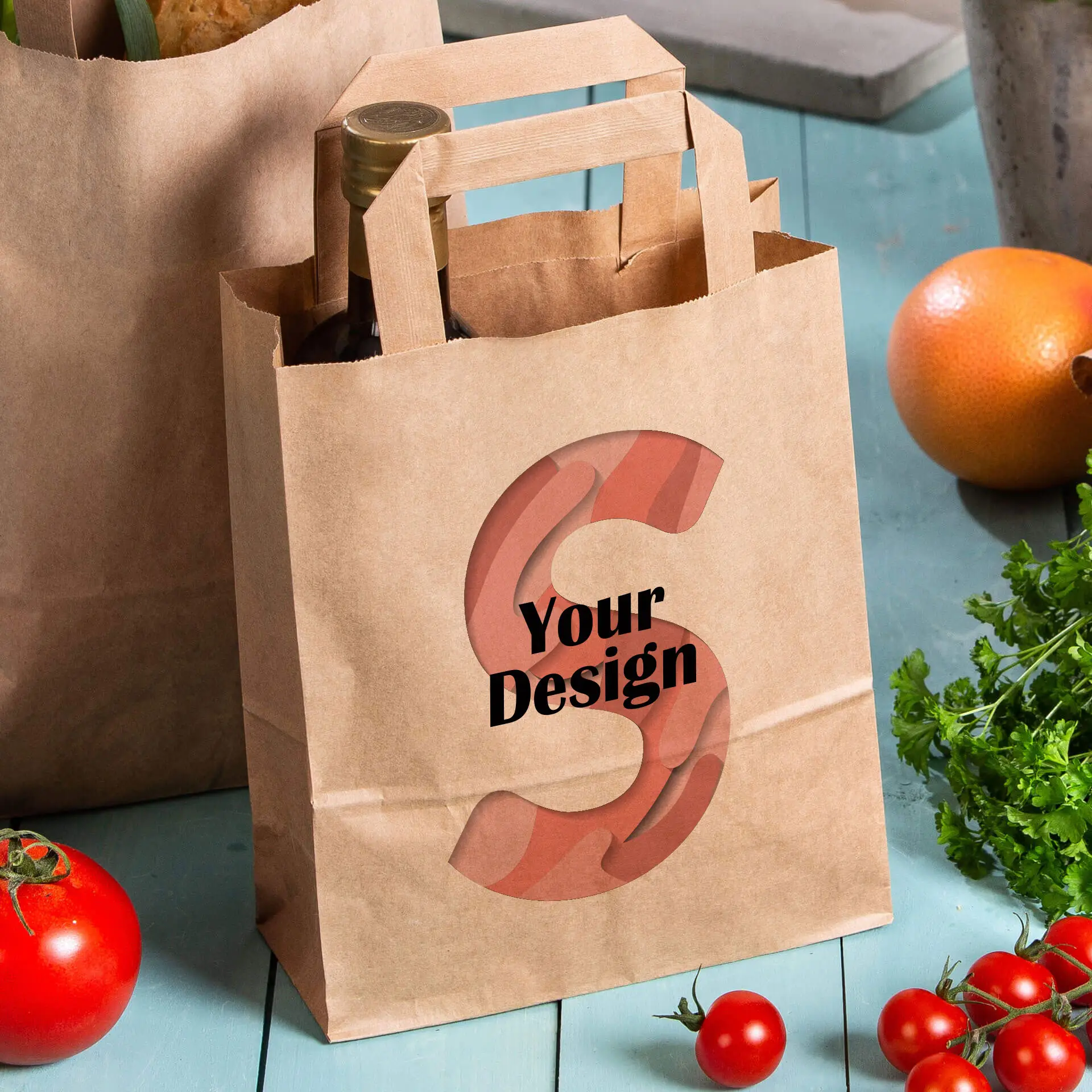 Brown paper carrier bag with customizable design featuring the letter "S" and text "Your Design," alongside fresh produce.