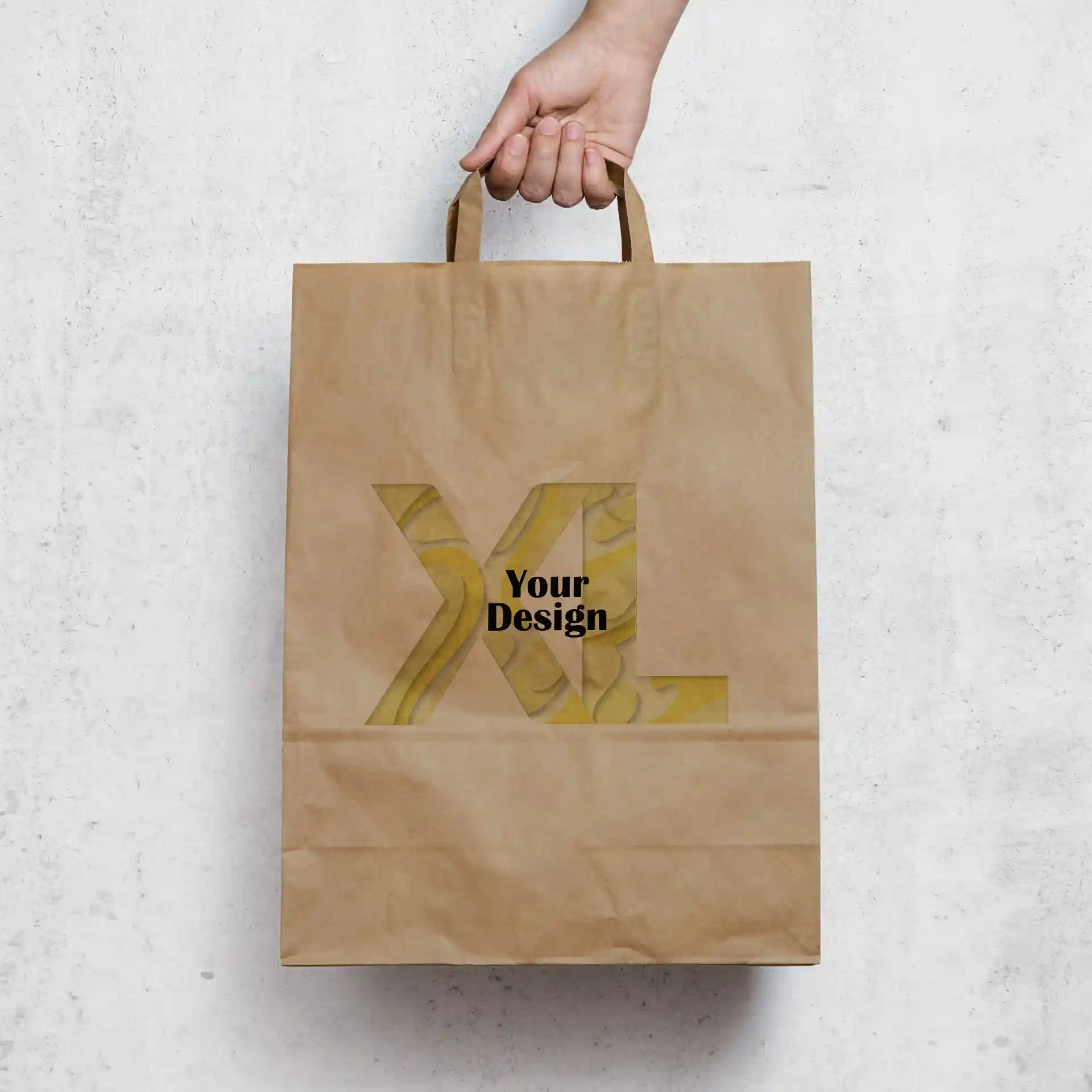 Brown paper carrier bag with a rectangular shape, featuring a hand holding it and a design area marked "Your Design" in black.