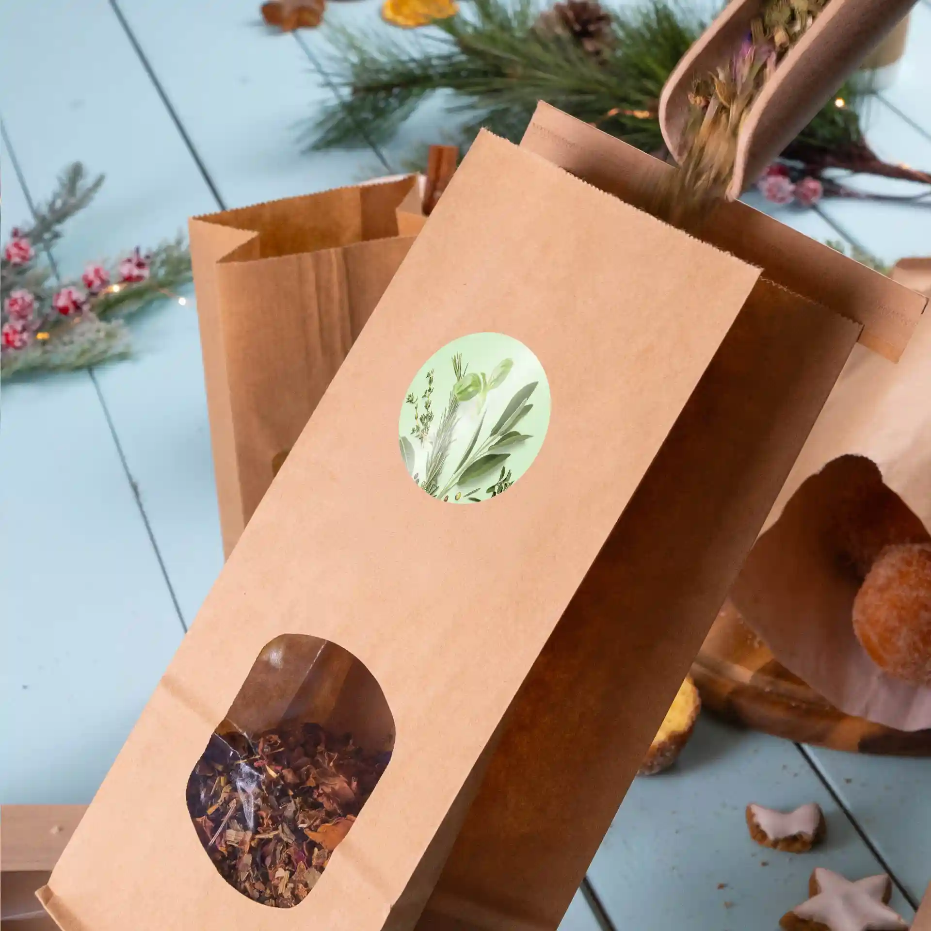 Brown paper bag with a transparent window showing loose herbs, and a round label with a plant design on the front.