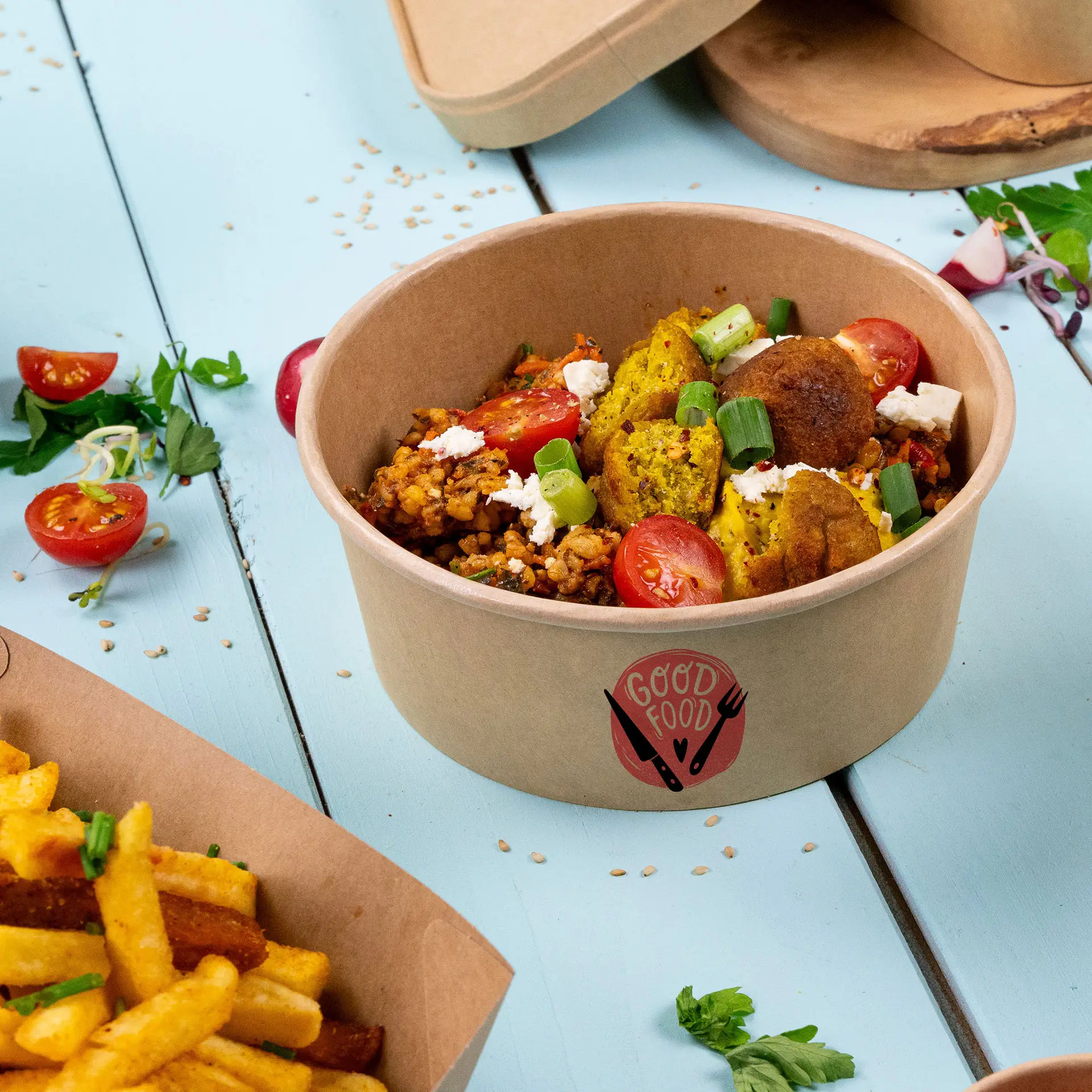 Runde Pappschüssel mit Salat, Tomaten und Kräutergarnitur, mit individuellem Druck, auf einer blauen Fläche.