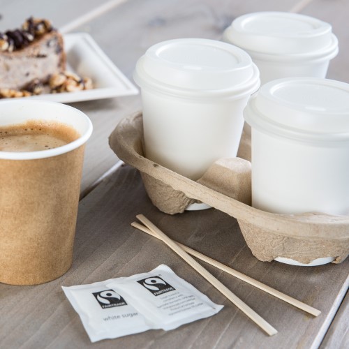 Sustainable white paper cups in a cup holder with lids , stirrers and fair trade sugar sachets