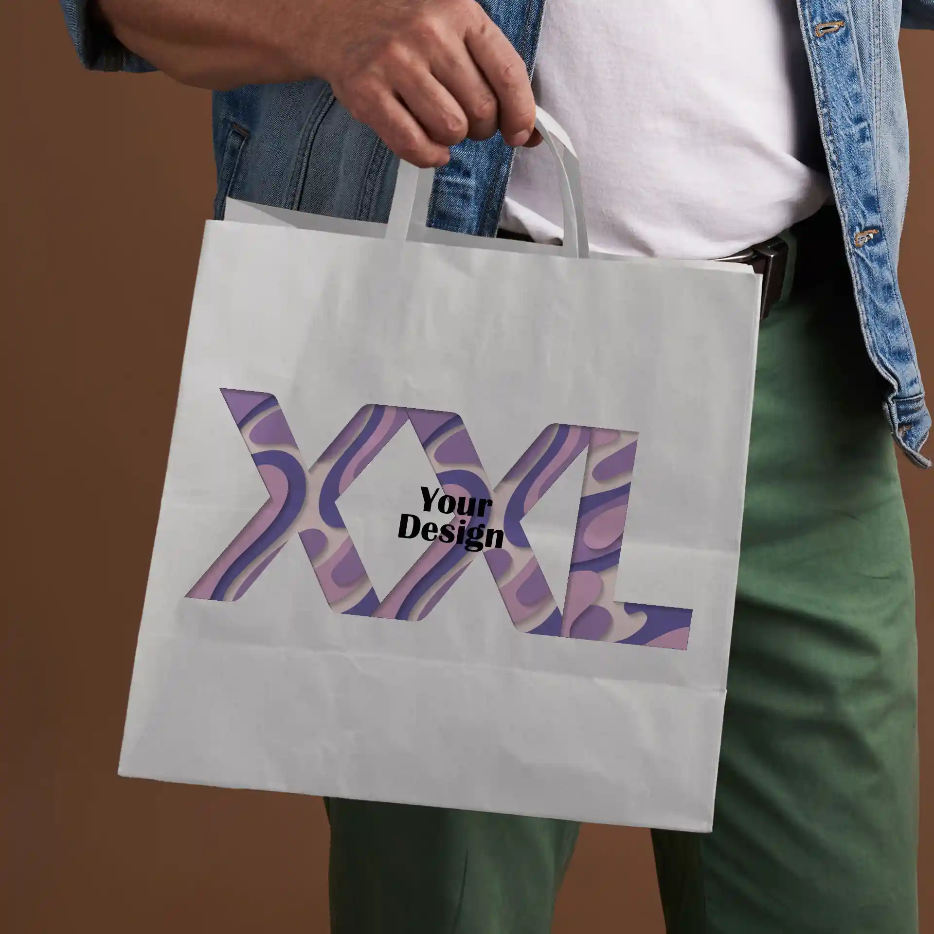 Weißer Tragetasche aus Papier, gehalten von einer Person, mit einem Ausschnitt-Design und dem Text "XXL" und "Dein Design".